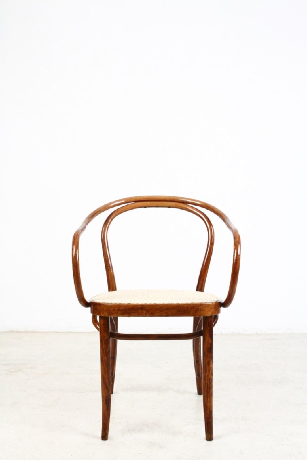 This iconic chair was designed by August Thonet in 1900 and produced by Thonet in Czechoslovakia. It features a stained beech bentwood frame and a rattan seat. Wood and rattan are in good condition and they are ready to be the highlight of your