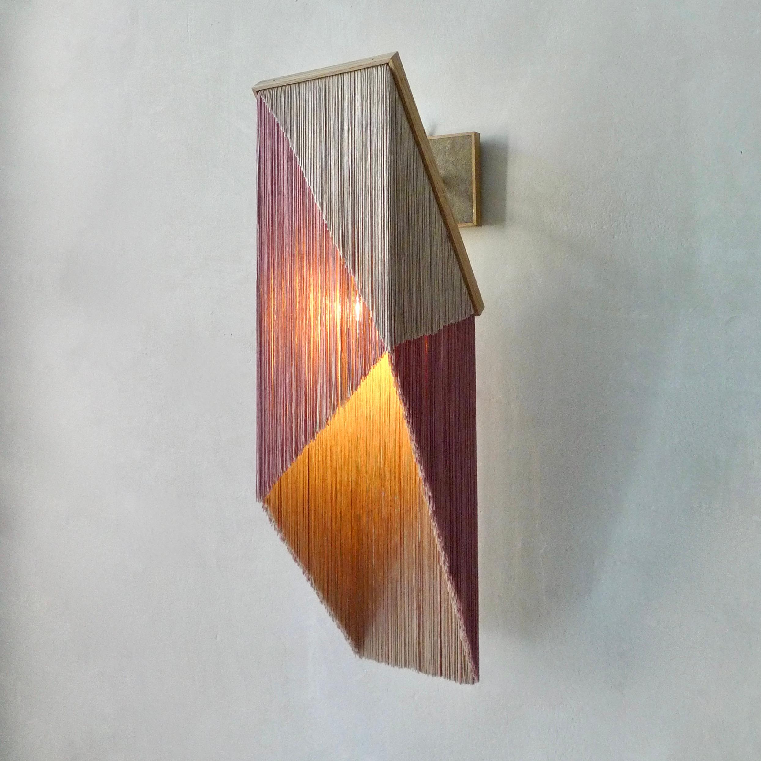 No. 28 Wall Lamp by Sander Bottinga
Dimensions: H 46 - 70 x W 31 x D 22 - 30 cm
Materials: Brass, Wood, Leather, Viscose Fringes
Variations available.

Handmade in brass, wood, leather and 3 double layered viscose fringes in
geometric cut and