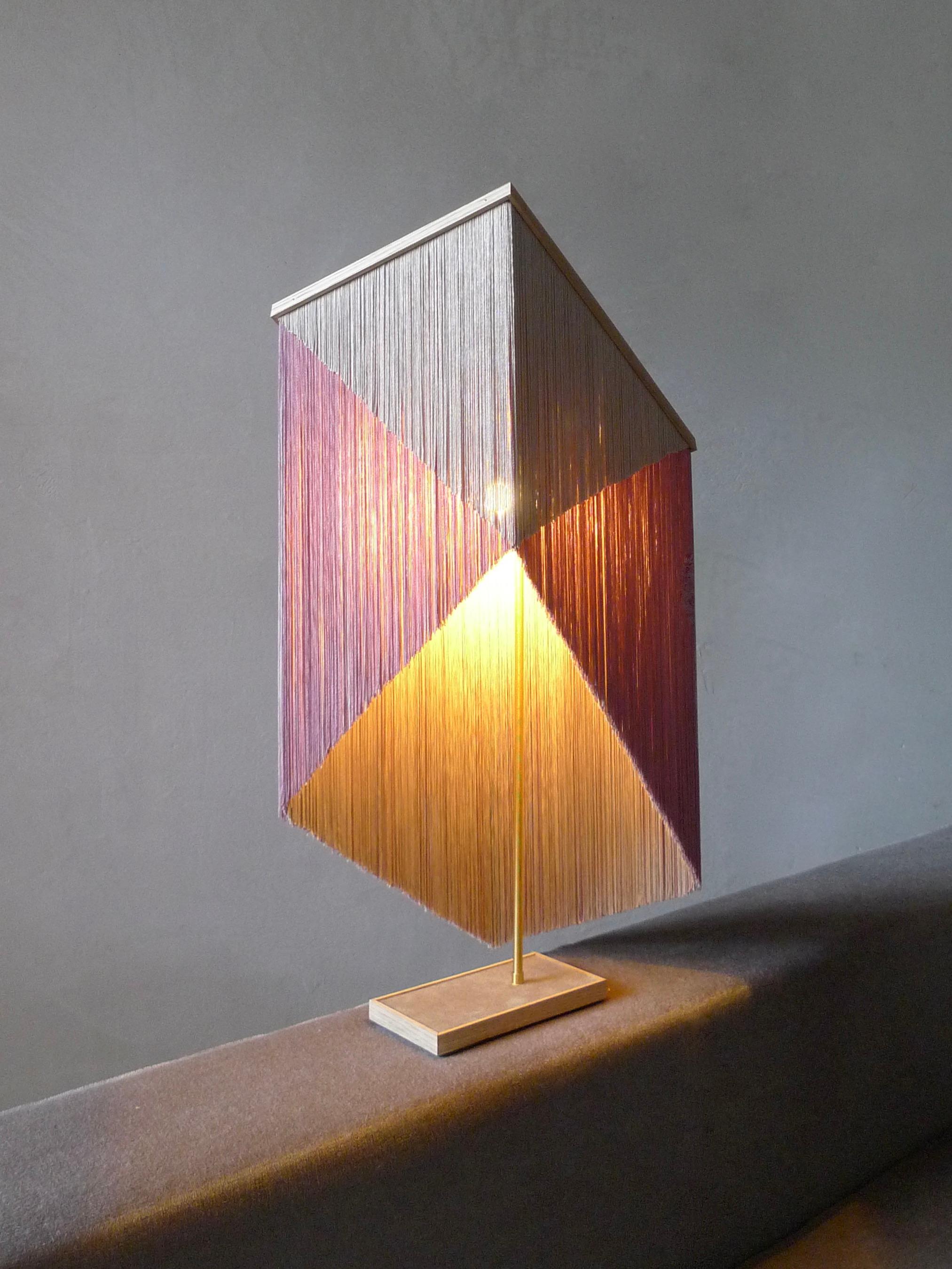 No. 30 table lamp by Sander Bottinga.
Object size 3.
Dimensions: H 60-75 x W 37 x D 26 cm.
Materials: brass, wood, leather, viscose fringes
Variations available. 

Handmade in brass, wood, leather and 3 double layered viscose fringes in
geometric