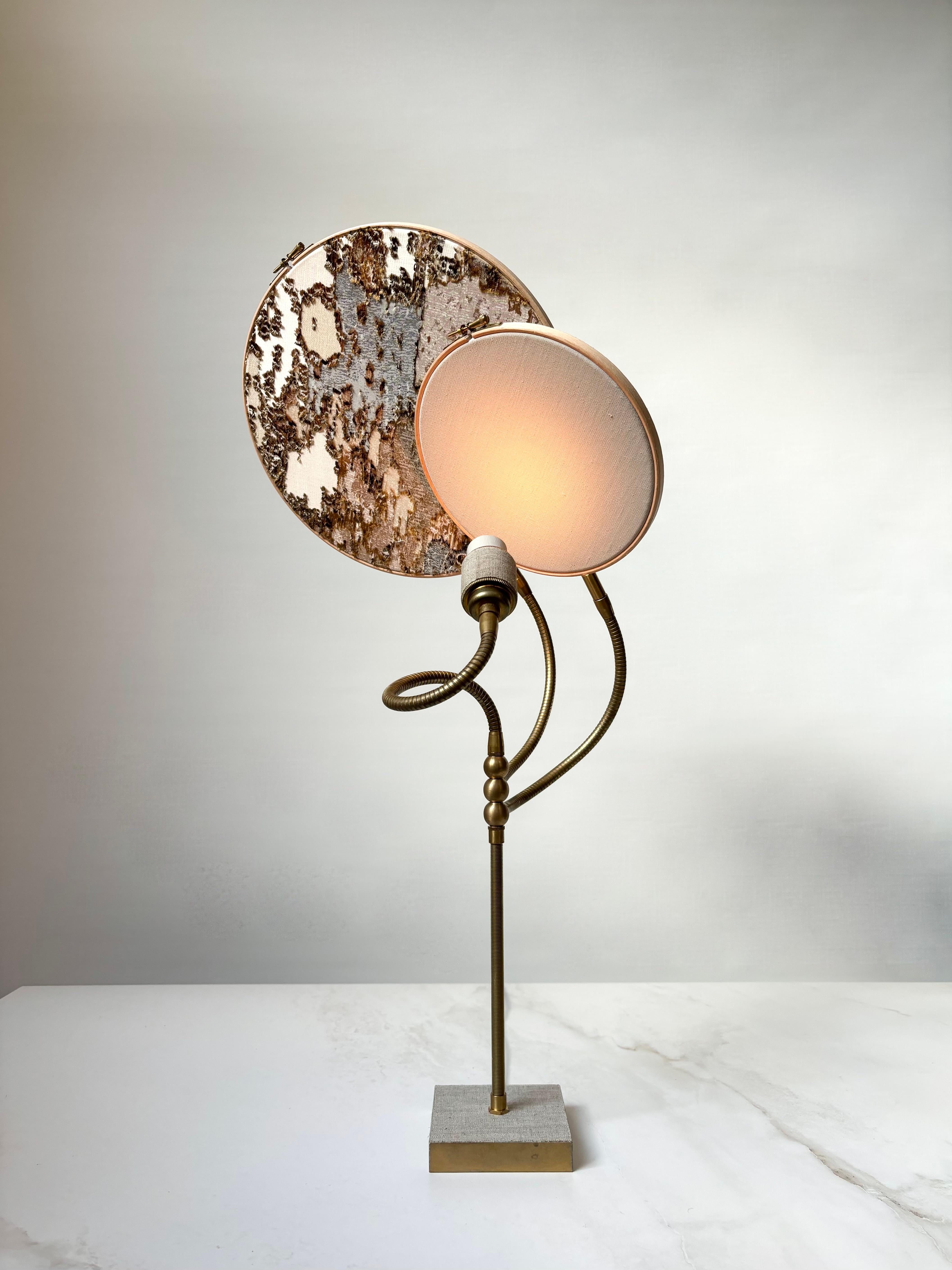 No 32 Lampe de table, 2 cercles, par Sander Bottinga
Dimensions : D&H 30 cm x L 40 cm x H 68 cm
MATERIAL : laiton, bois, lin gris peint à la main, motif brodé de marbre en soie, viscose, coton, cuir.

Disponible avec 2 cercles ou 1