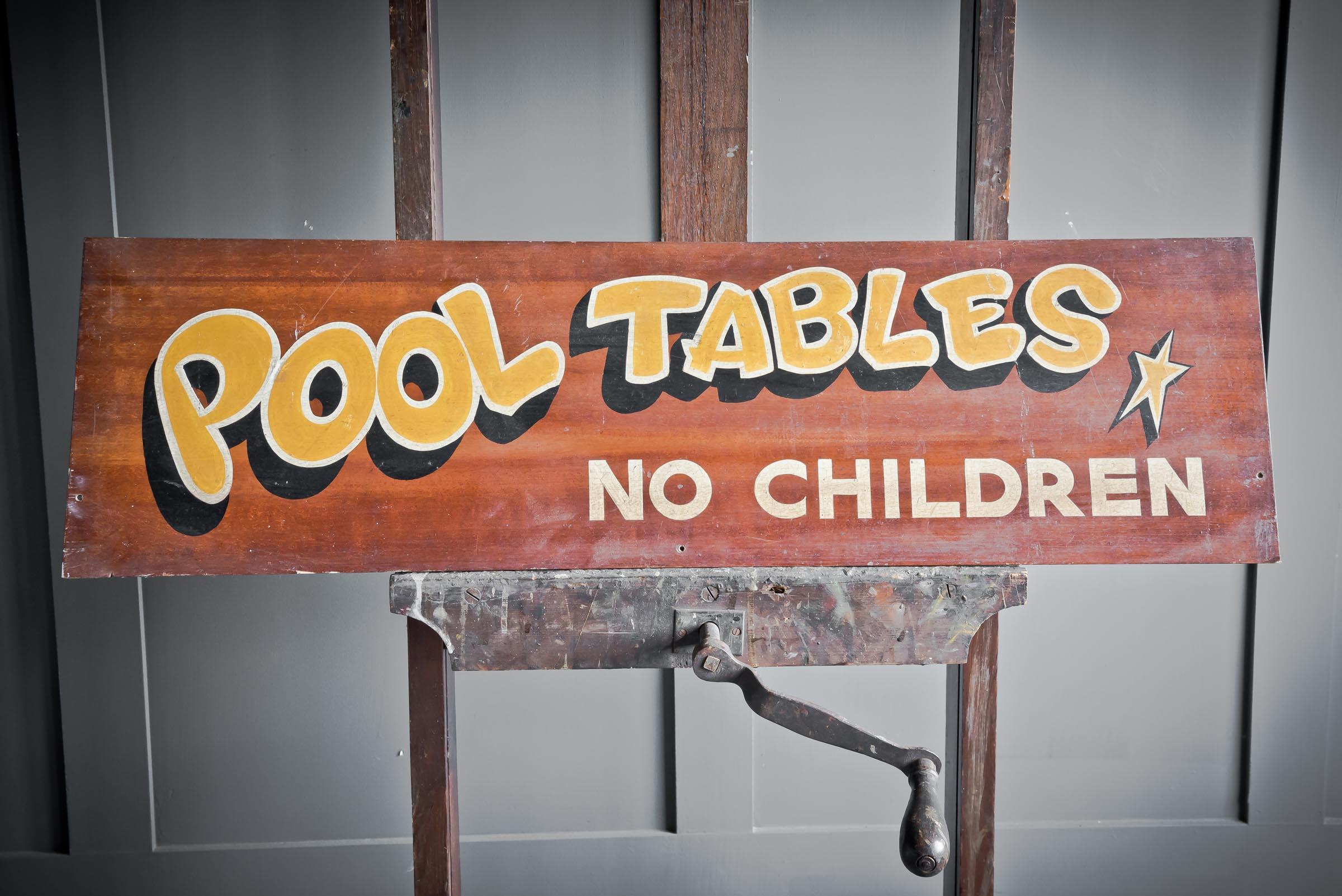 Retro 'Pool Tables' wooden sign, handpainted with yellow bubble lettering.
