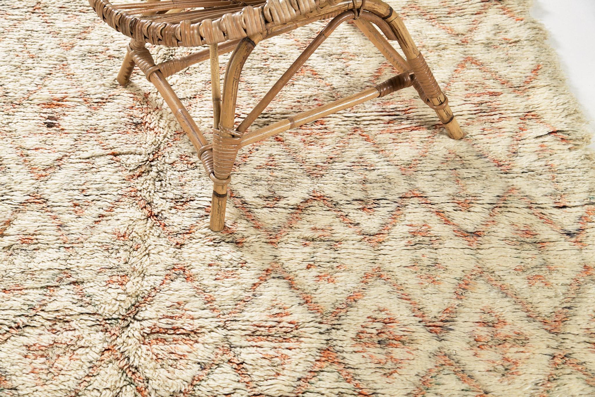 A Beni Ourain vintage Moroccan in ivory, coral, and mint colors. The rug's cohesive colors are weaved together into symbolic diamond motifs in a repeating pattern. This rug's charming and beautiful wool pile texture will add character to any space. 