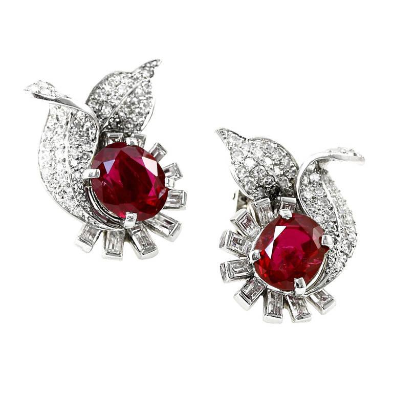 An exceptional pair of no heat burmese ruby earrings, each weighing over three carats, accented aesthetically with diamond baguette and old european cut diamonds. The earrings accompany a gemological certificate from AGL stating its origin as Burma,