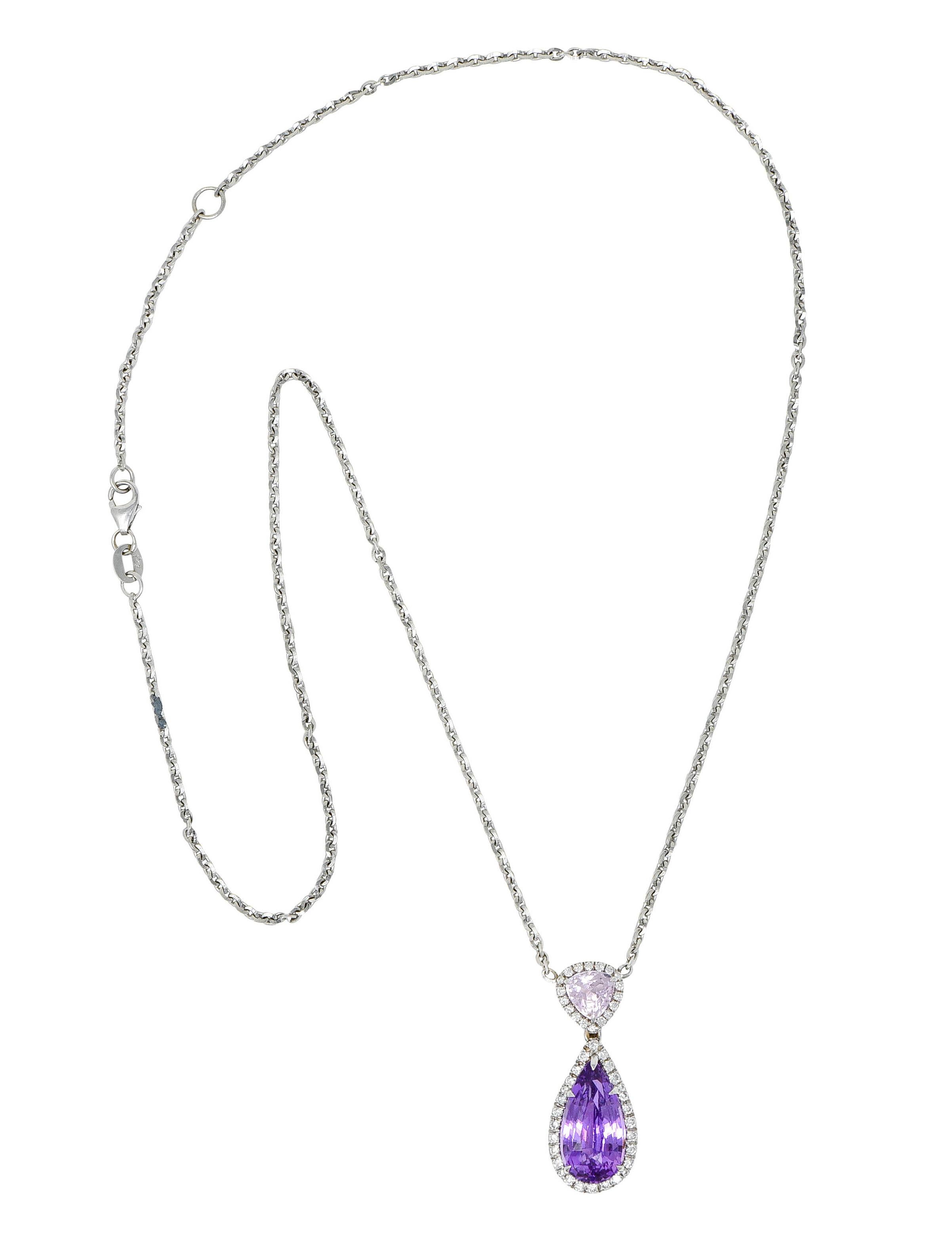 Faceted cable chain necklace centers a triangular surmount suspending a drop

Surmount features a triangular cushion cut kunzite gemstone - light pinkish purple in color

Contrasting a mixed pear cut sapphire weighing approximately 5.25