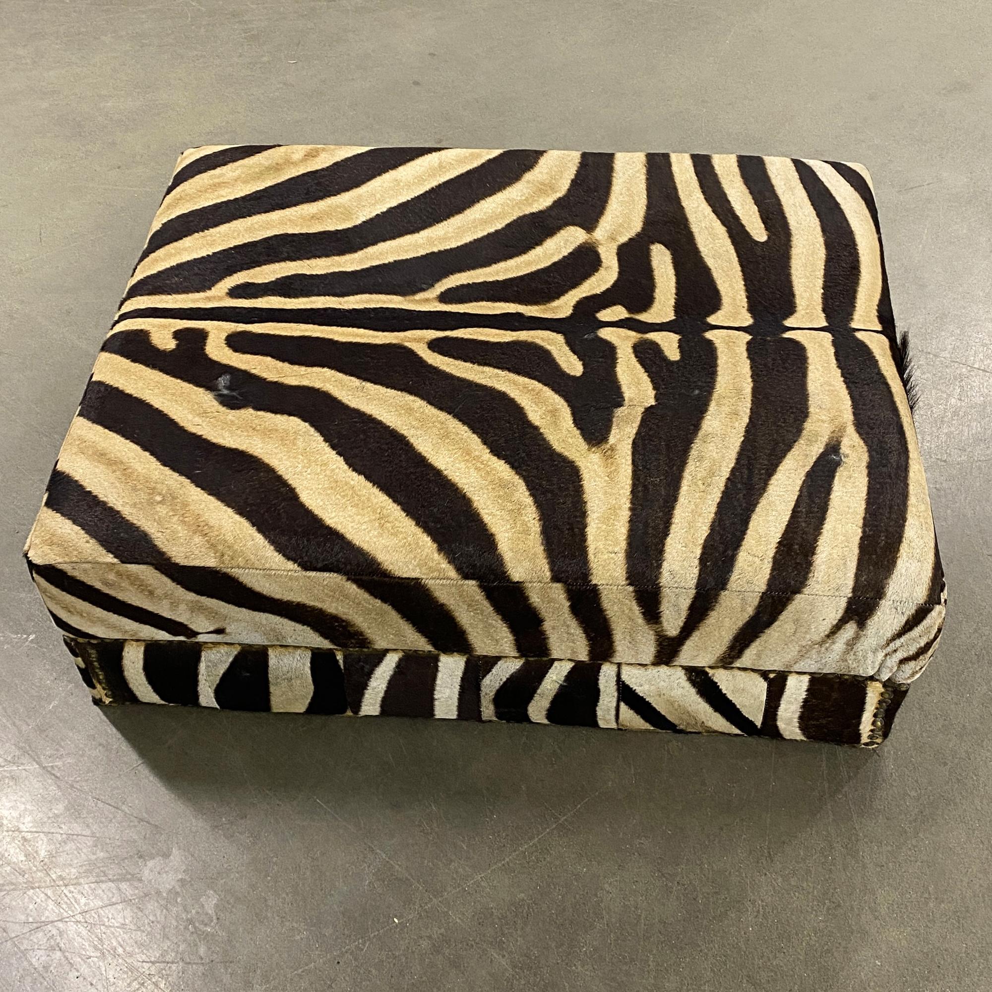 Available to Ship and owned for 2 years. Features a beautiful Burchell Zebra hide that covers the entire ottoman with a black cover on the bottom. This ottoman was produced in South Africa and used at a Vineyard lobby office.
FEATURES 
- Burchell
