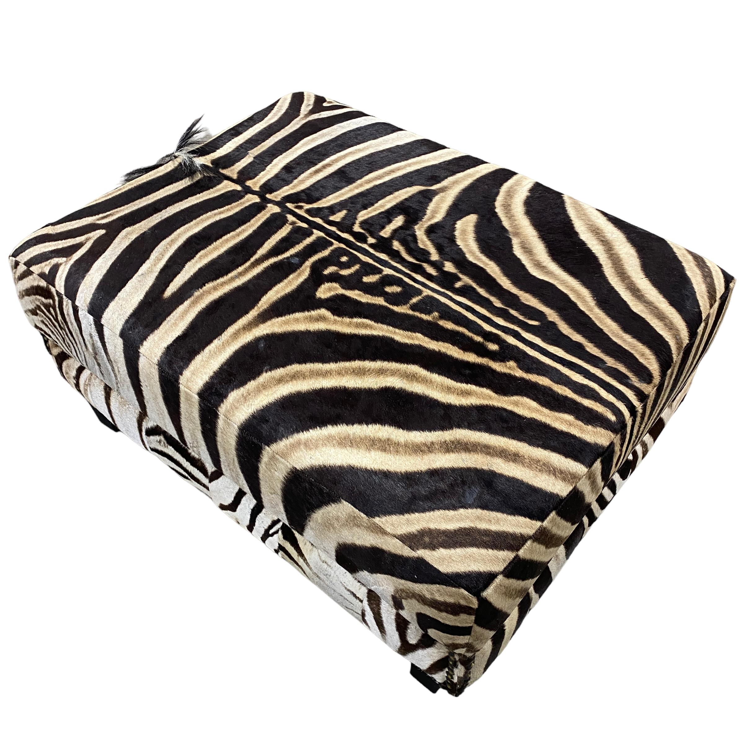 Disponible à l'expédition et détenu pendant 2 ans. Ce pouf est recouvert d'une magnifique peau de zèbre de Burchell qui recouvre l'ensemble du pouf, avec une couverture noire sur le dessous. Ce pouf a été produit en Afrique du Sud et utilisé dans un