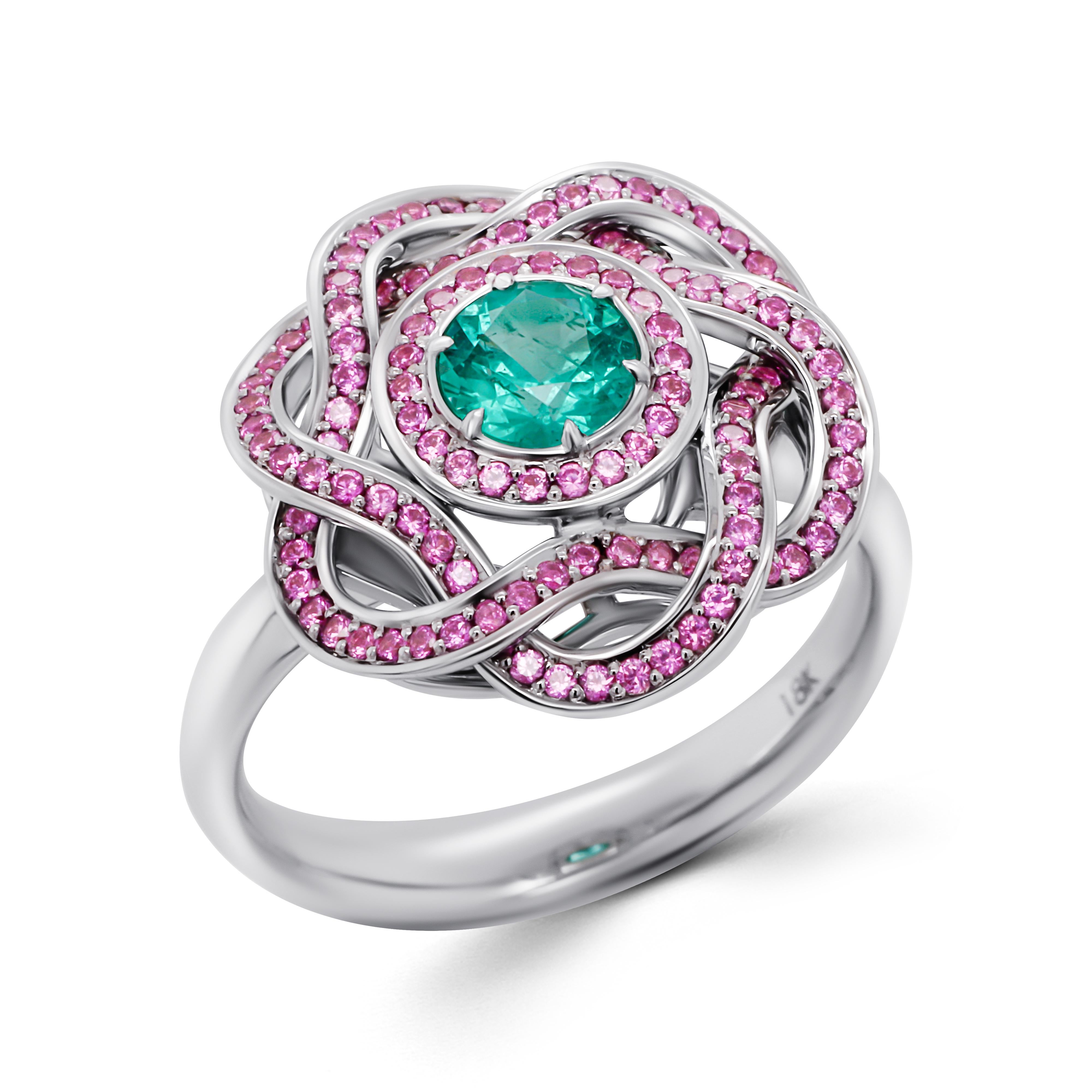 An elegant floral design inspired by late motifs of XIX century. 
Flower's leaves are embodied in sophisticated intertwined lines adorned with Pink Sapphires represent a multi-level structure. The untreated round-cut Russian Emerald in significant