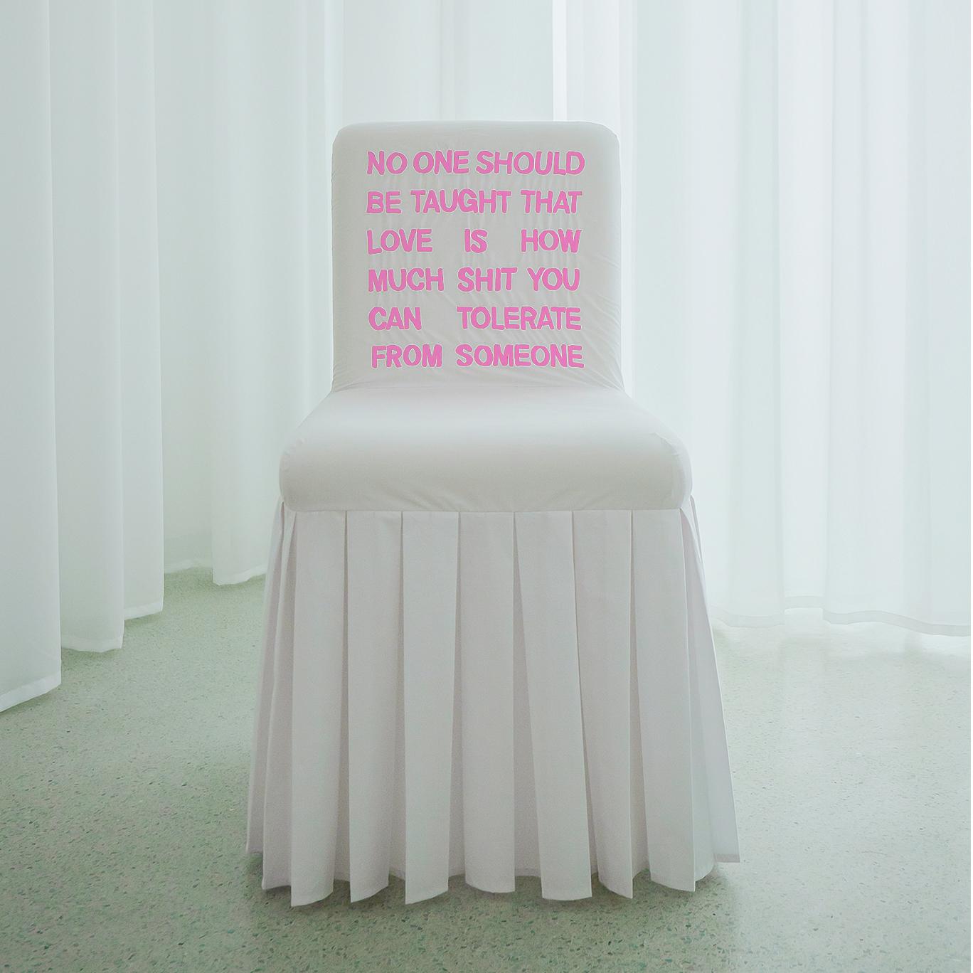 “No-One-Should” chair is inspired by the artistic form of classical Chinese furniture and modern Chinese big-letter slogans. It is covered in cotton fabric (white) or fine silk (other color options), hand-embroidered with a text about domestic