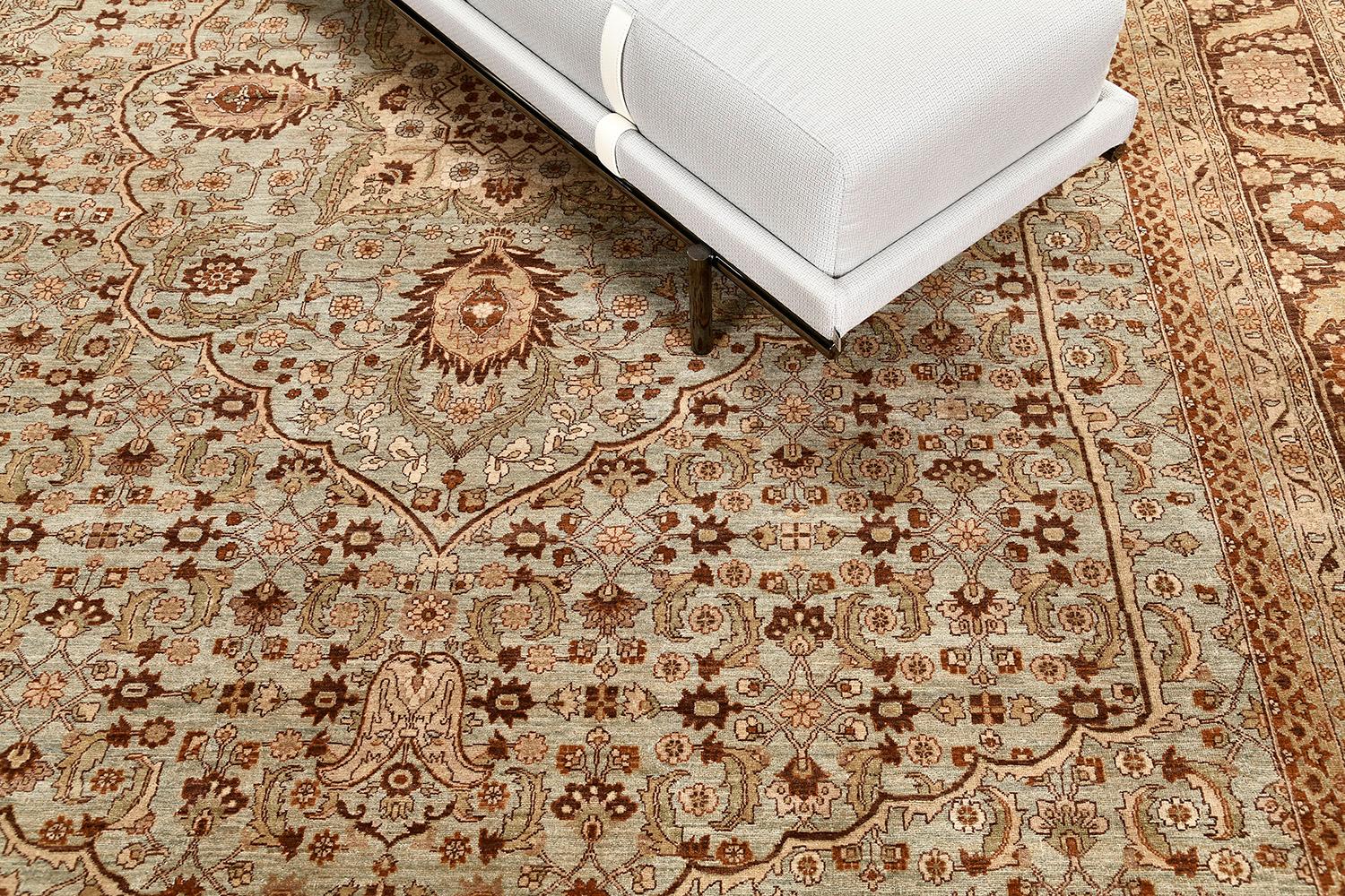 A spectacular Tabriz Hadji Halili style rug that emanates its natural brilliance. The arabesque central medallion forms as a preparation to eventually highlight elements as it cascades throughout this sophisticated rug. Warm and earthy tones of