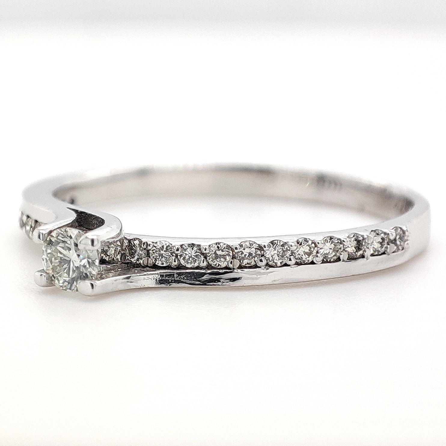 FOR US CUSTOMER NO VAT!

This charming engagement diamond ring is adorned with a total of 0.24 carats distributed across 24 diamonds, set delicately in a 14K white gold band. The diamonds boast exceptional clarity falling within the VS1 to VS2