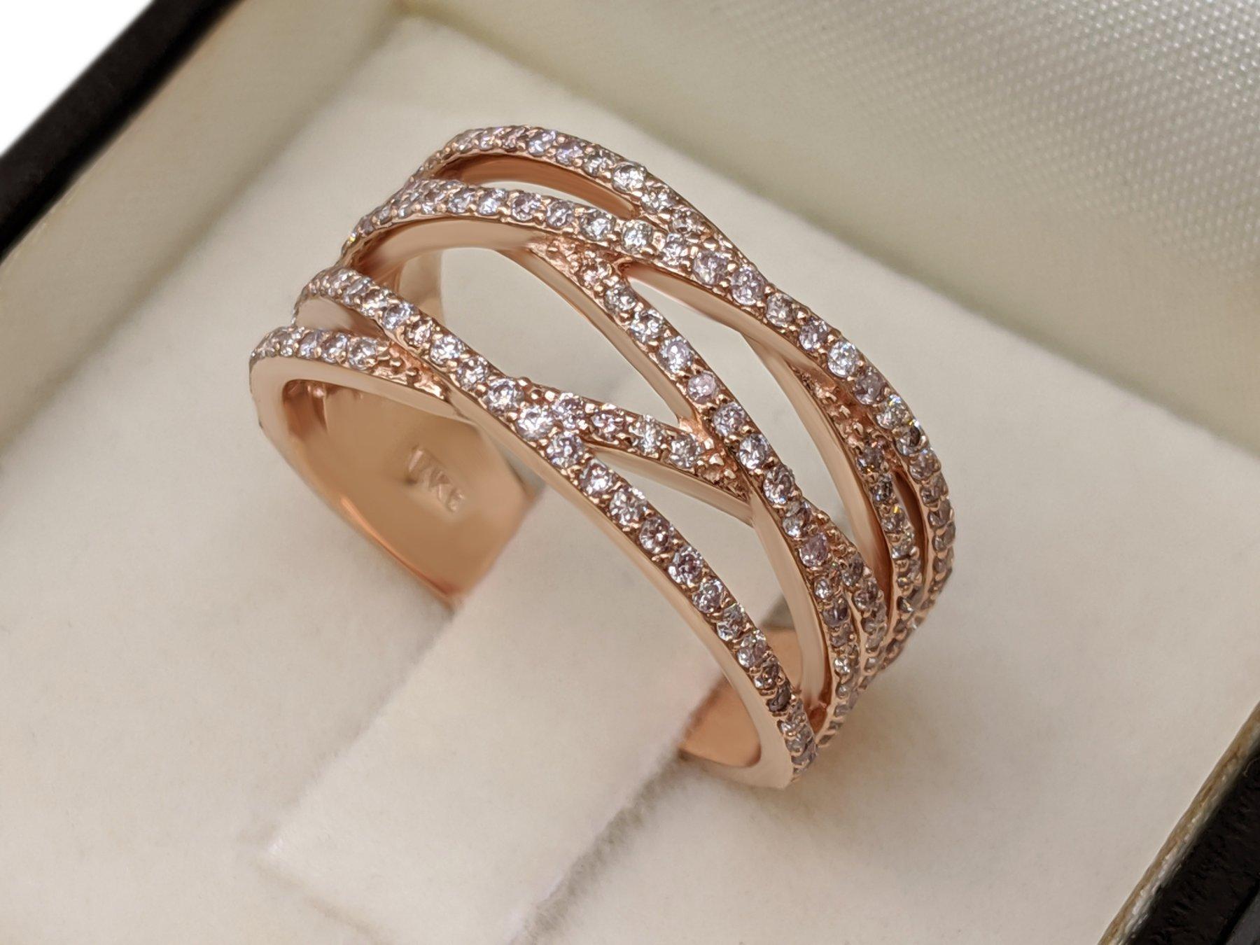 This exquisite ring features 0.75 carats of natural colored light pink and fancy light pink diamonds, beautifully arranged in a 14 kt rose gold setting. The delicate pink hues of the 1388 diamonds are perfectly complemented by the warm, romantic