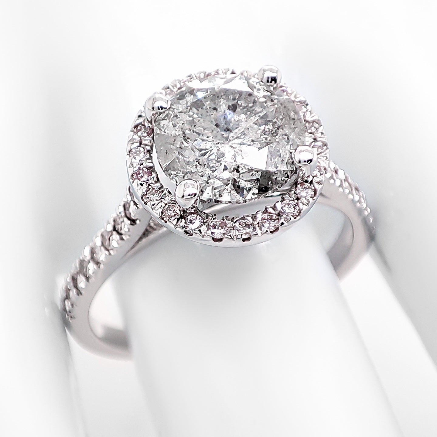FOR U.S. BUYERS NO VAT NO CUSTOMS FEES

his exquisite ring features a dazzling 2.11-carat round diamond as the center stone, radiating brilliance and sophistication. Surrounding the center stone are 41 light pink diamonds, totaling 0.30 carats with