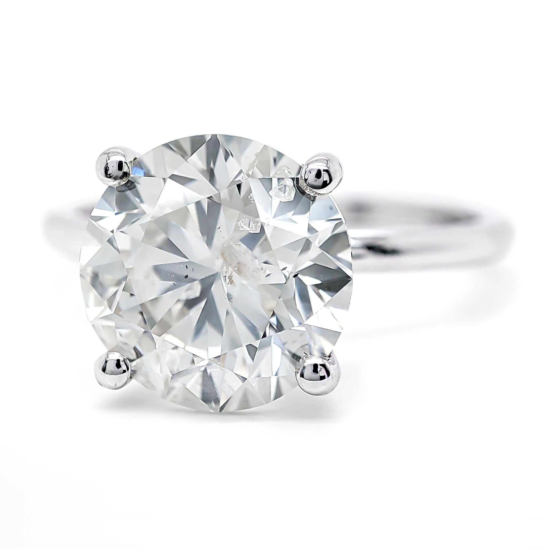 FOR U.S. BUYERS NO VAT NO CUSTOMS FEES

This elegant ring features a dazzling 3.07-carat round brilliant natural diamond, boasting a classic J color that exudes timeless beauty and sophistication. Set in 14 kt white gold, the ring weighs 2.78 grams,