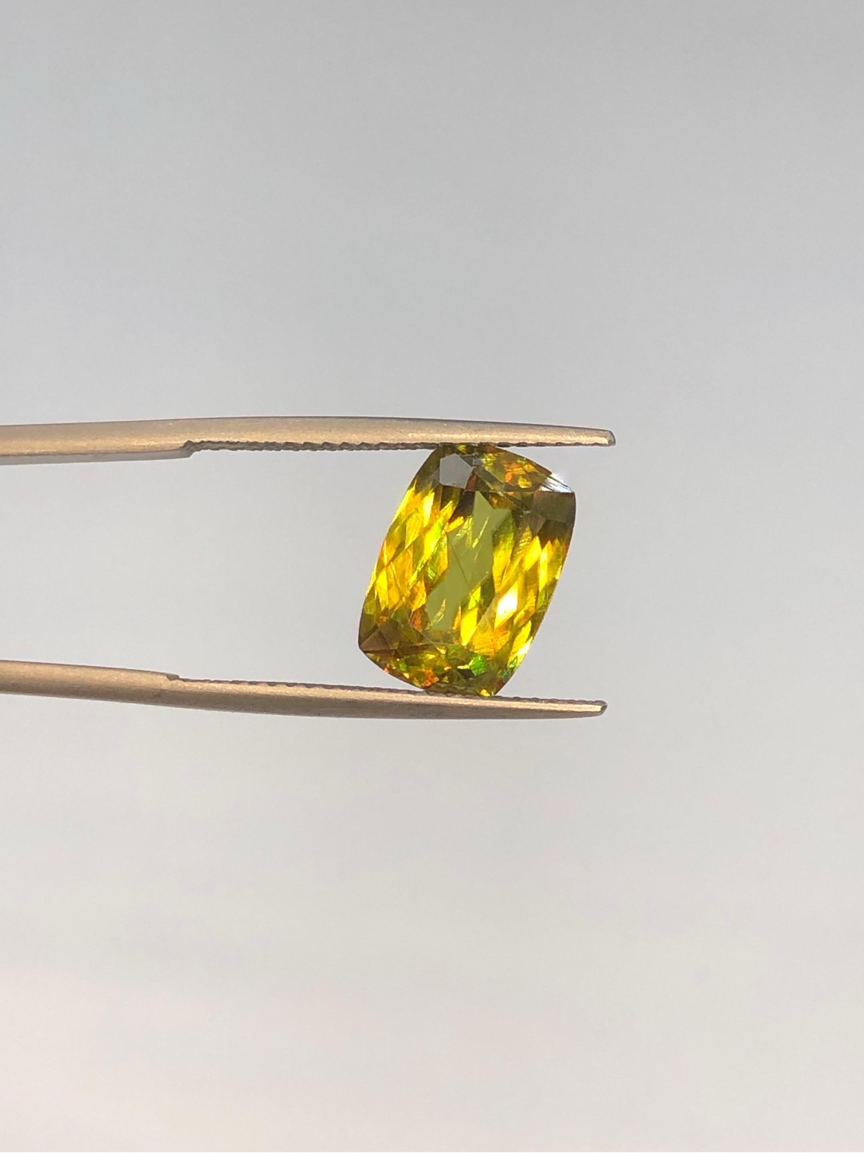 Introducing a dazzling 4.60 ct Sphene gemstone from Madagascar, boasting a mesmerizing greenish-yellow hue. With SI clarity, it showcases vibrant sparks of yellow, green, and orange, making it a captivating addition to any collection or jewelry