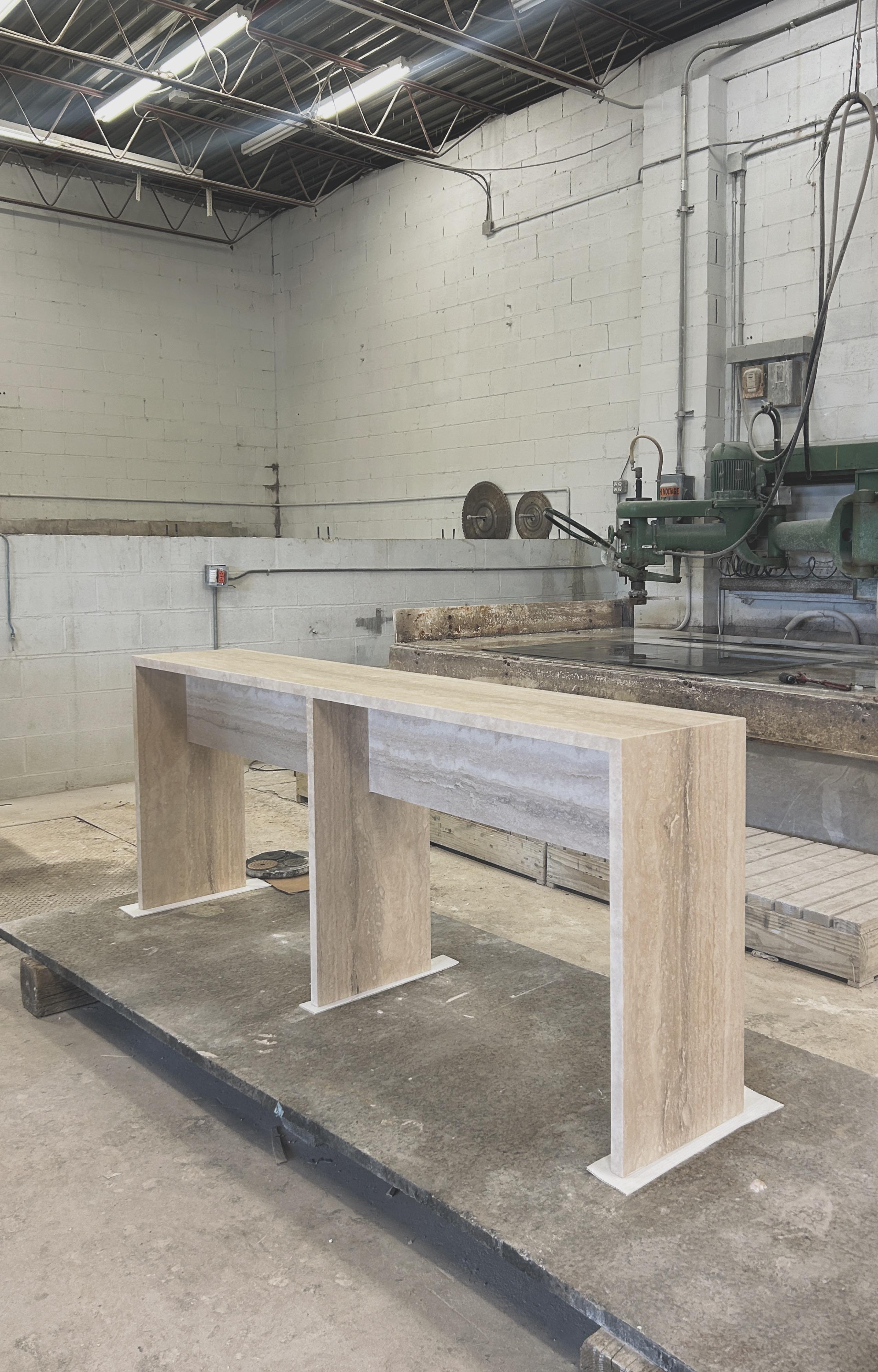 Meticulously and simply crafted with solid 3cm thick travertine slabs, the proportions create a lightness of form juxtaposing the materiality.

A continuation of Coffee Table Nº 106, this console is extruded to desk height with a cross beam for
