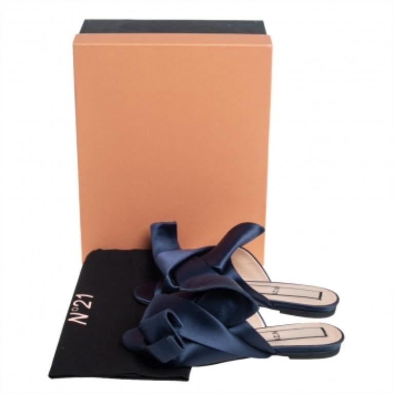 Die Nº21 Flats mit ihren übertriebenen Knoten sind ein Statement-Paar, das Ihren Look auf eine ganz neue Ebene hebt. Sie sind kunstvoll aus Satin in einem Blauton gefertigt und an der Spitze offen. Diese Pantoletten sind mit bequemen Einlegesohlen