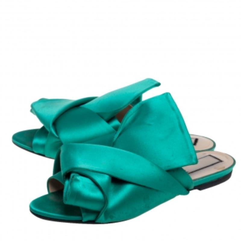 Characterized by exaggerated knots, the Nº21 mules are a statement pair and can take your look to a whole new level. They are skillfully crafted from satin in a green hue and feature open-toes. These flat mules offer maximum comfort while walking.