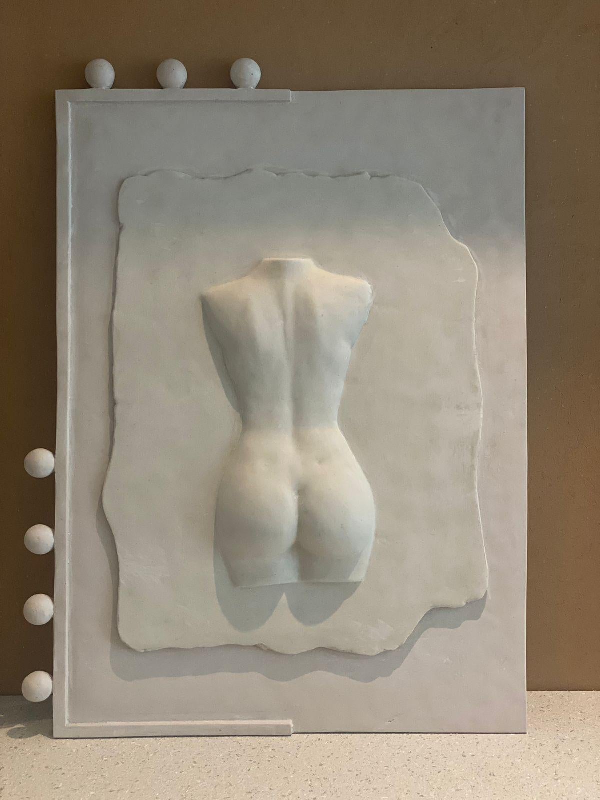 A  female torso sculpture wall art piece that calls on references of Renaissance paintings and academic ceramic sculptures. This female body piece explores historic interpretations of the female body within a contemporary context, resulting in a