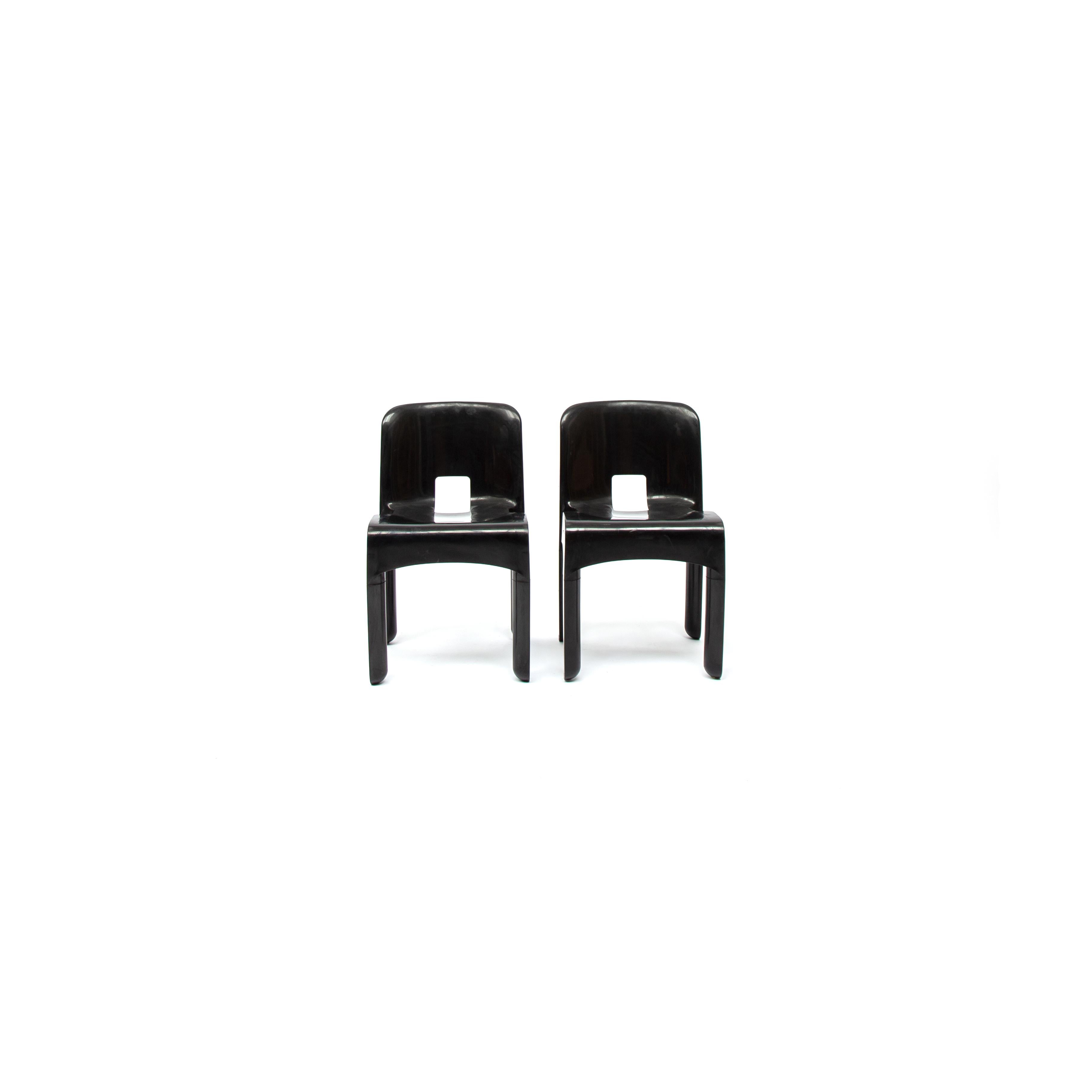 A set of 2 black plastic dining chairs Model No. 4860 Universale designed by Joe Colombo 1965-1967. Produced by Kartell, Noviglio, Milano. The dining chairs are labeled underneath. Absolutely great feature from the dining chairs is a stack ability.
