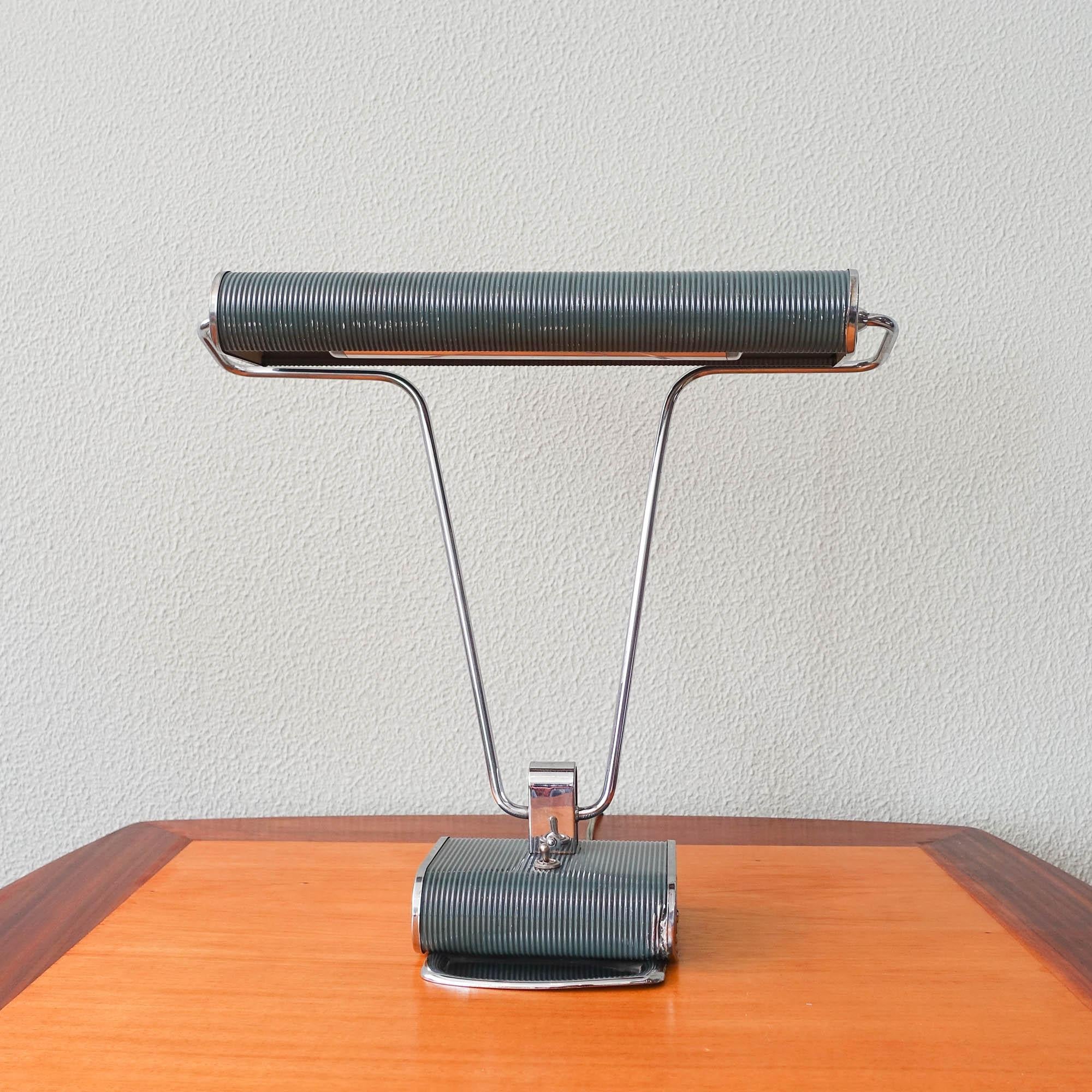 Cette lampe de bureau No. 71 a été conçue par Eileen Gray pour Jumo, en France, dans les années 1930. Elle est composée d'un tube en laiton chromé, d'une base ondulée en aluminium et d'un abat-jour avec un bras mobile des deux côtés. Très solide et