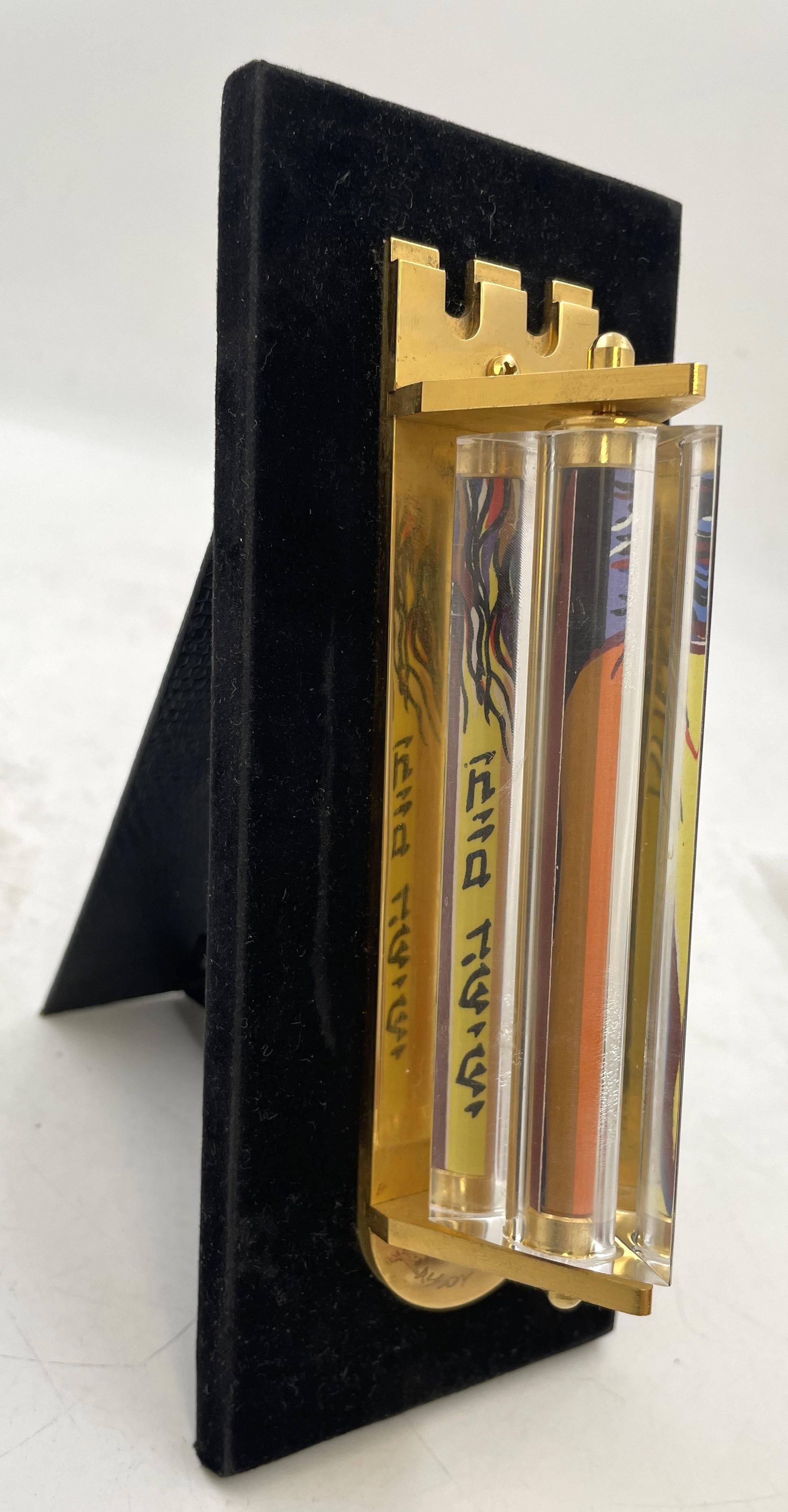 Made by Israel artist Noam Naim Basson, this artistic glass mezuzah with a felt back measures 7 1/2'' by 3'' by 4 1/4'' in depth overall (mezuzah measures 6'' by 1 1/3''). It is signed and numbered 90 out of 777. 

Please feel free to ask us any