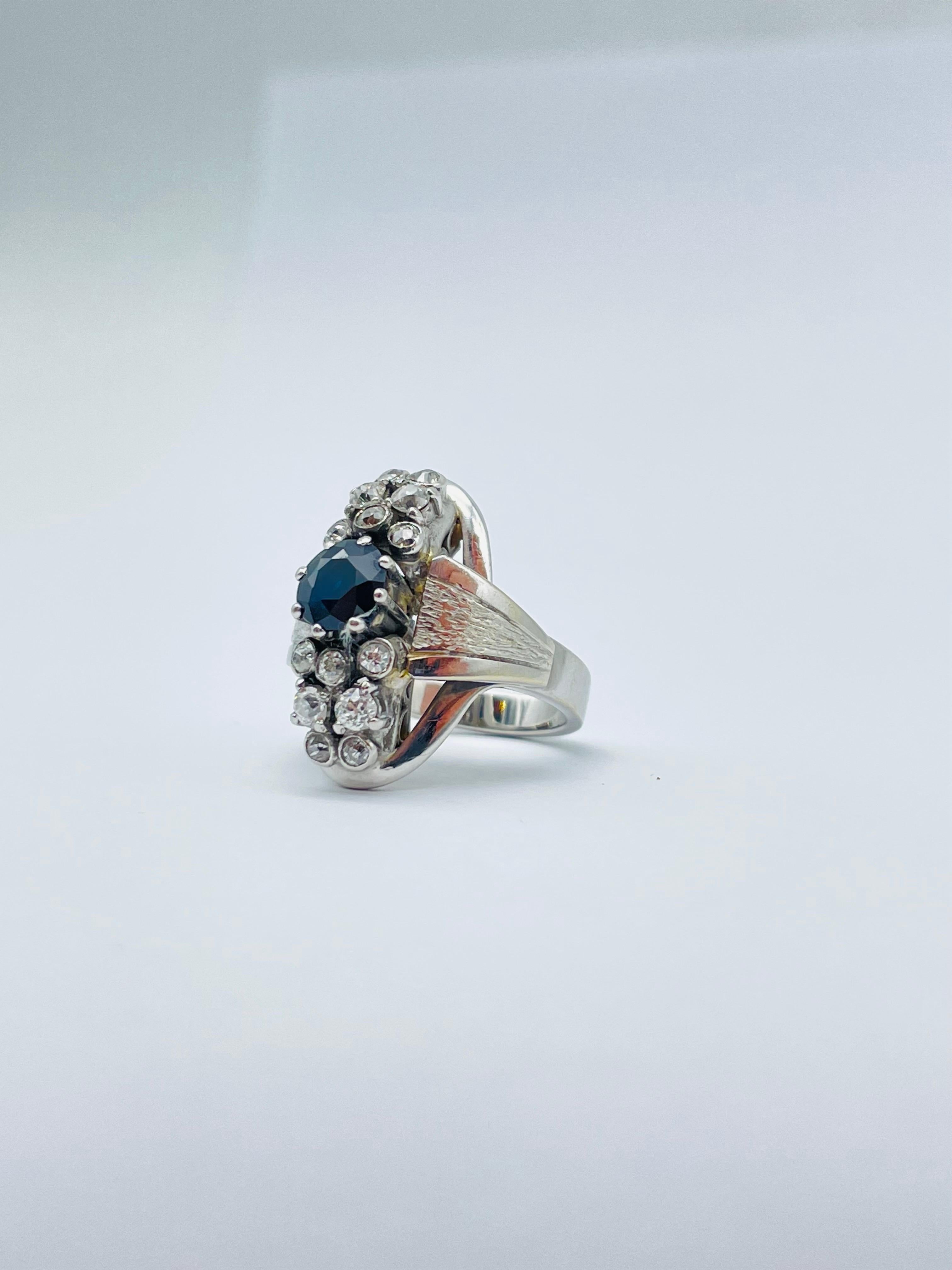 Behold the majestic 14k white gold ring with diamonds and sapphire, a true masterpiece of jewelry design. Expertly crafted from the finest materials, this ring boasts a solid 14 karat white gold band that serves as a pristine canvas for the dazzling