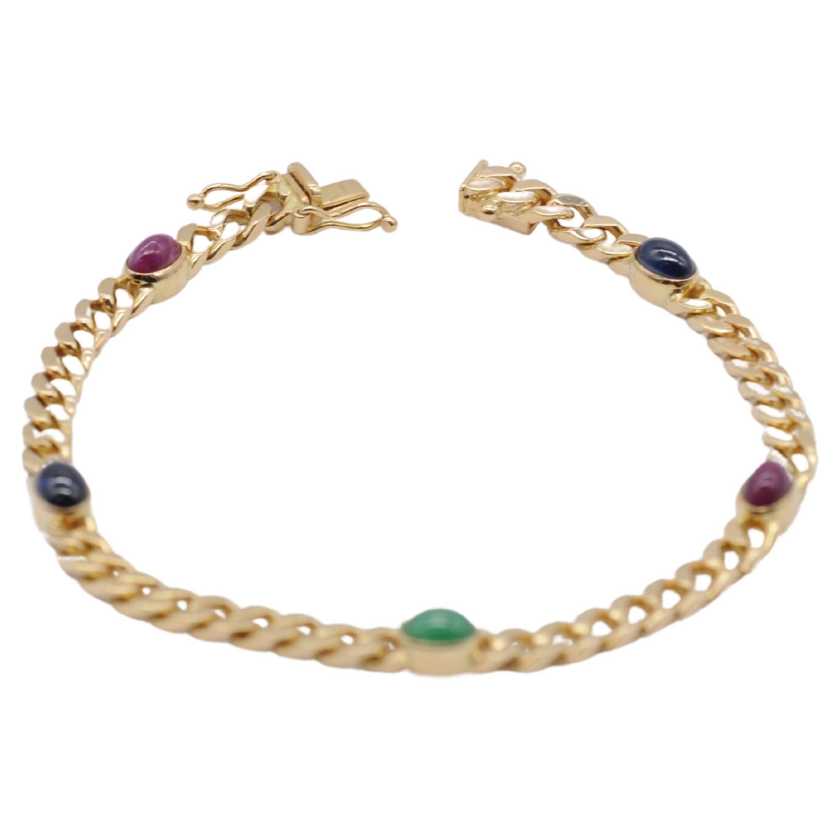 Introducing an extraordinary piece of jewelry: a mesmerizing 14k yellow gold bracelet meticulously embellished with cabochon-cut sapphire, emerald, and ruby gemstones. This bracelet transcends mere adornment, becoming a beacon of sophistication and