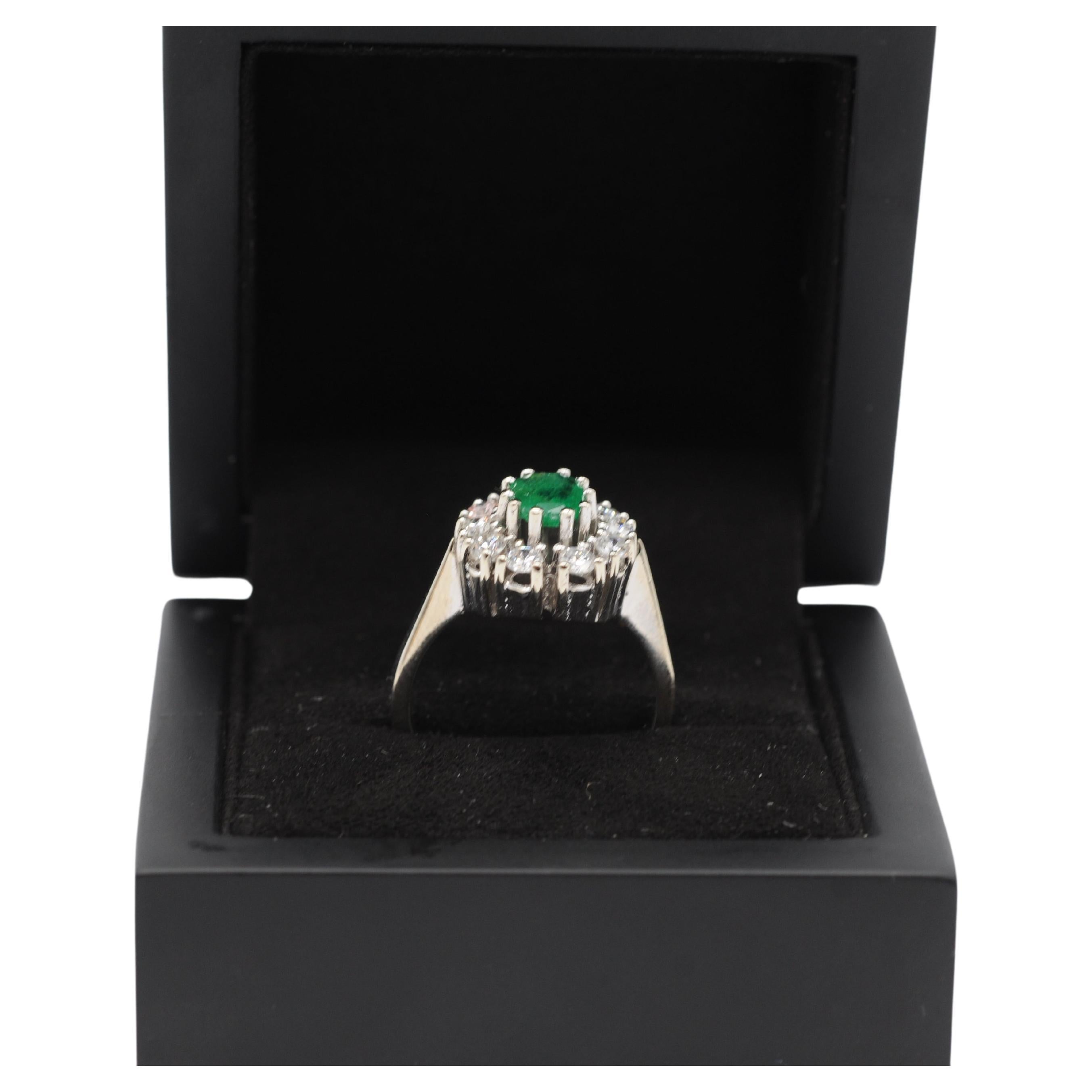 Presenting a breathtaking 14k white gold ring adorned with ten dazzling diamonds in brilliant cuts, accompanied by a stunning Colombian emerald with inclusions. The dimensions of the gemstones are as follows:

Emerald:Approximately Length: 7.5mm,