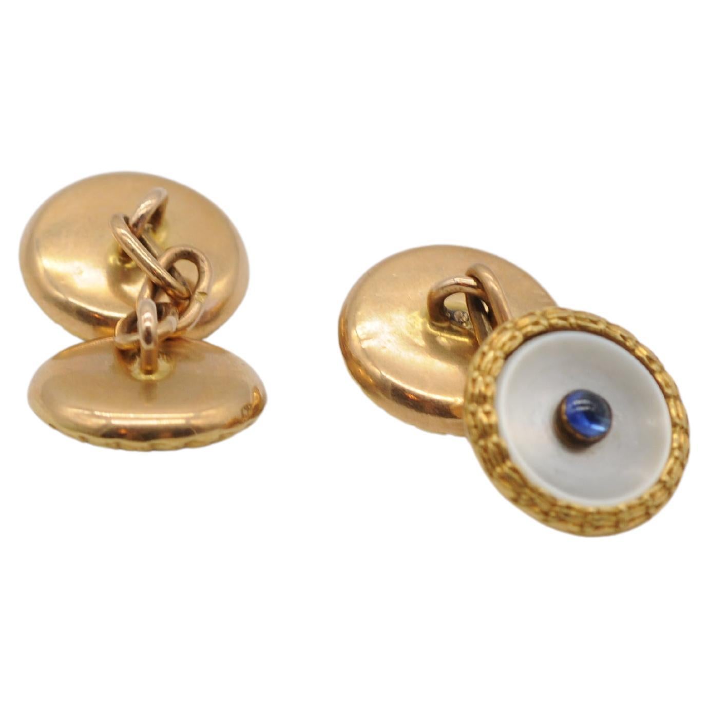 Indulge in the exquisite charm of these breathtaking 14k yellow gold cufflinks, adorned with luminous mother-of-pearl accents and delicate sapphire hints, showcasing a spectrum of stunning hues. Embrace elegance and sophistication with these dreamy