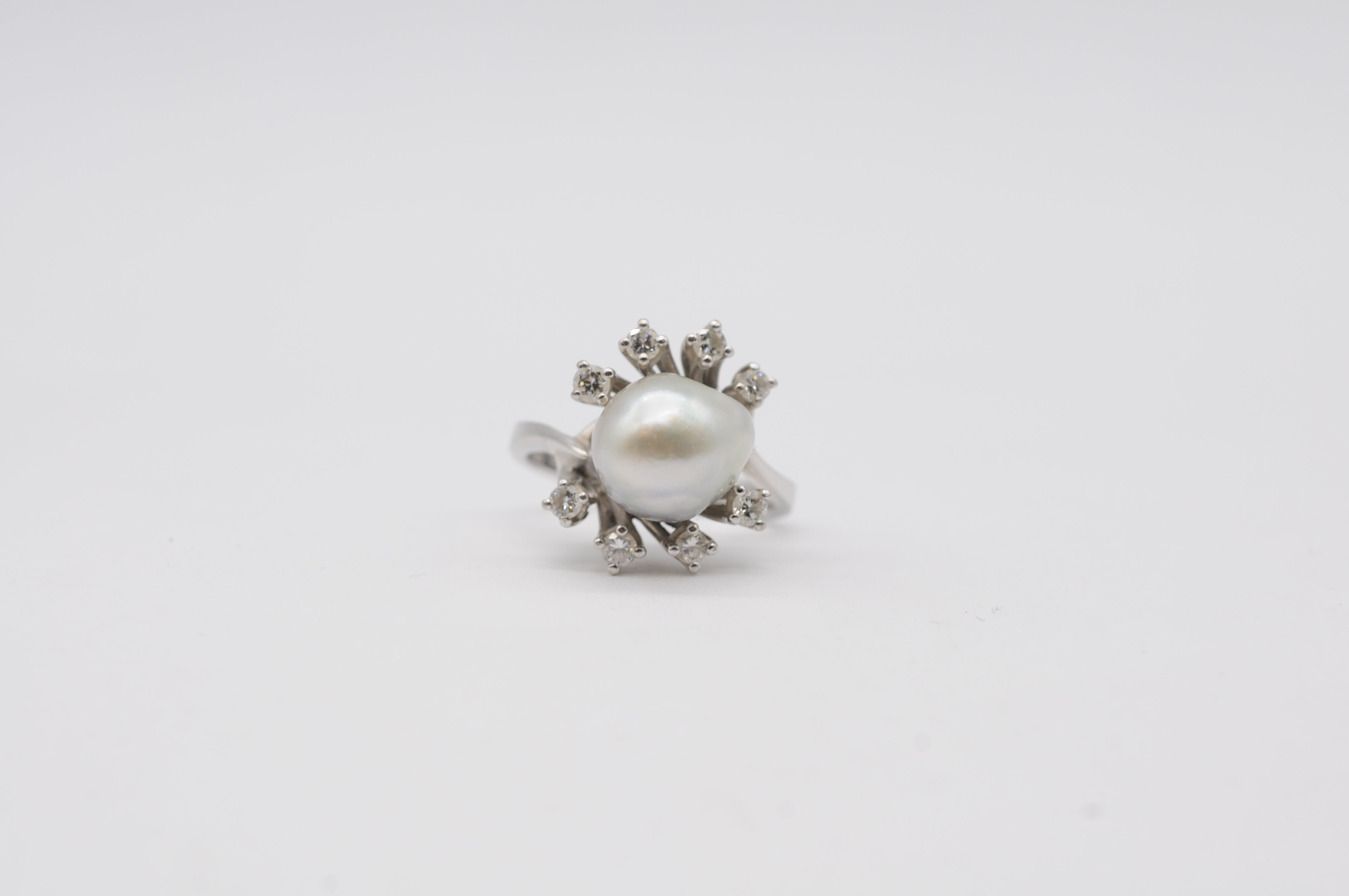 
Certainly! Here's a majestic description in English:

Prepare to be mesmerized by the majestic beauty of this stunning 14k white gold ring, adorned with a lustrous pearl at its center and surrounded by a total of 8 diamonds ranging in size from