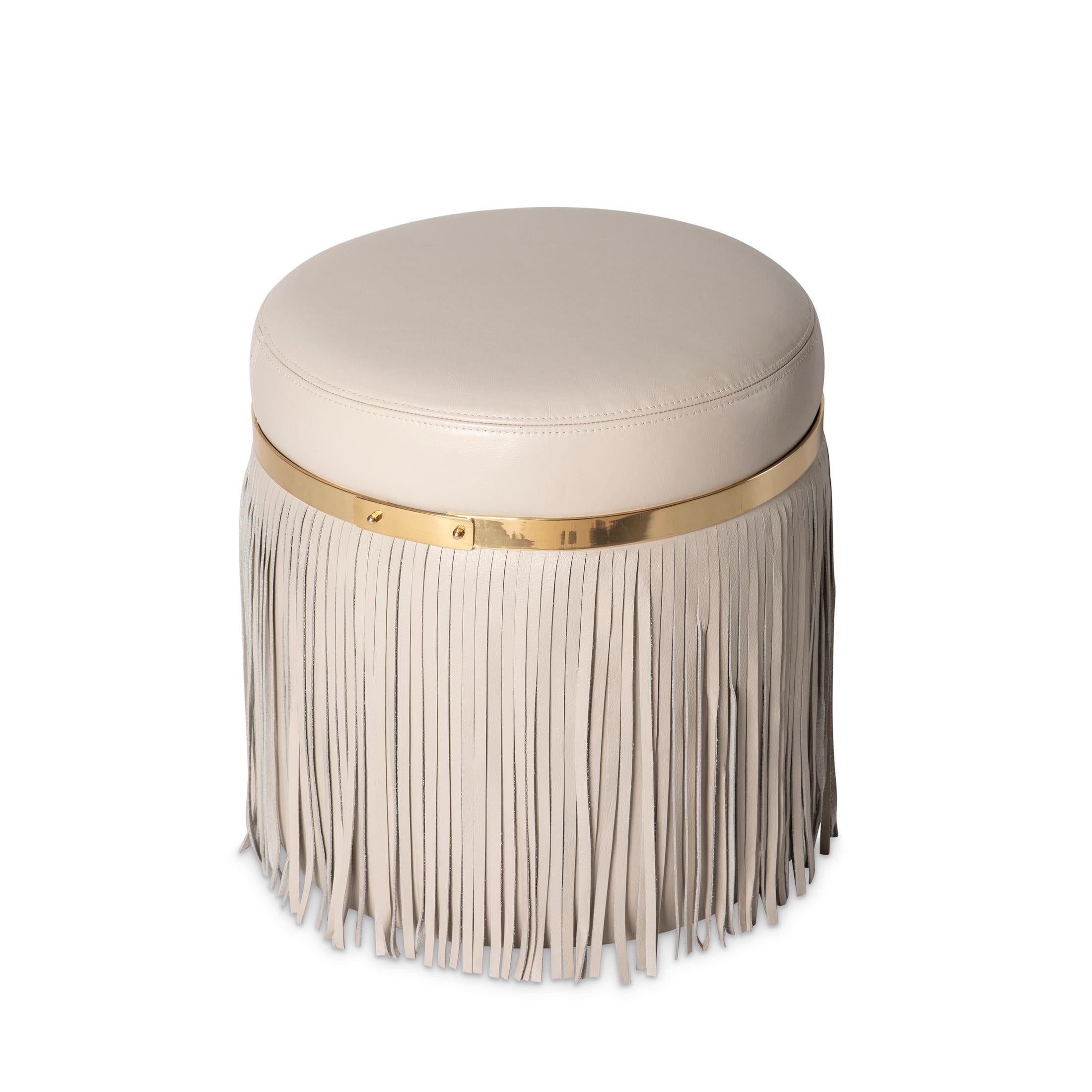 Il pouf Nobu presenta accenti in ottone, un rivestimento in pelle pregiata e uno strato di frange in pelle per un tocco di lusso.  
Il pouf Nobu fa parte della Collectional di Ngala Trading.  Questa linea meticolosamente realizzata incarna lusso,