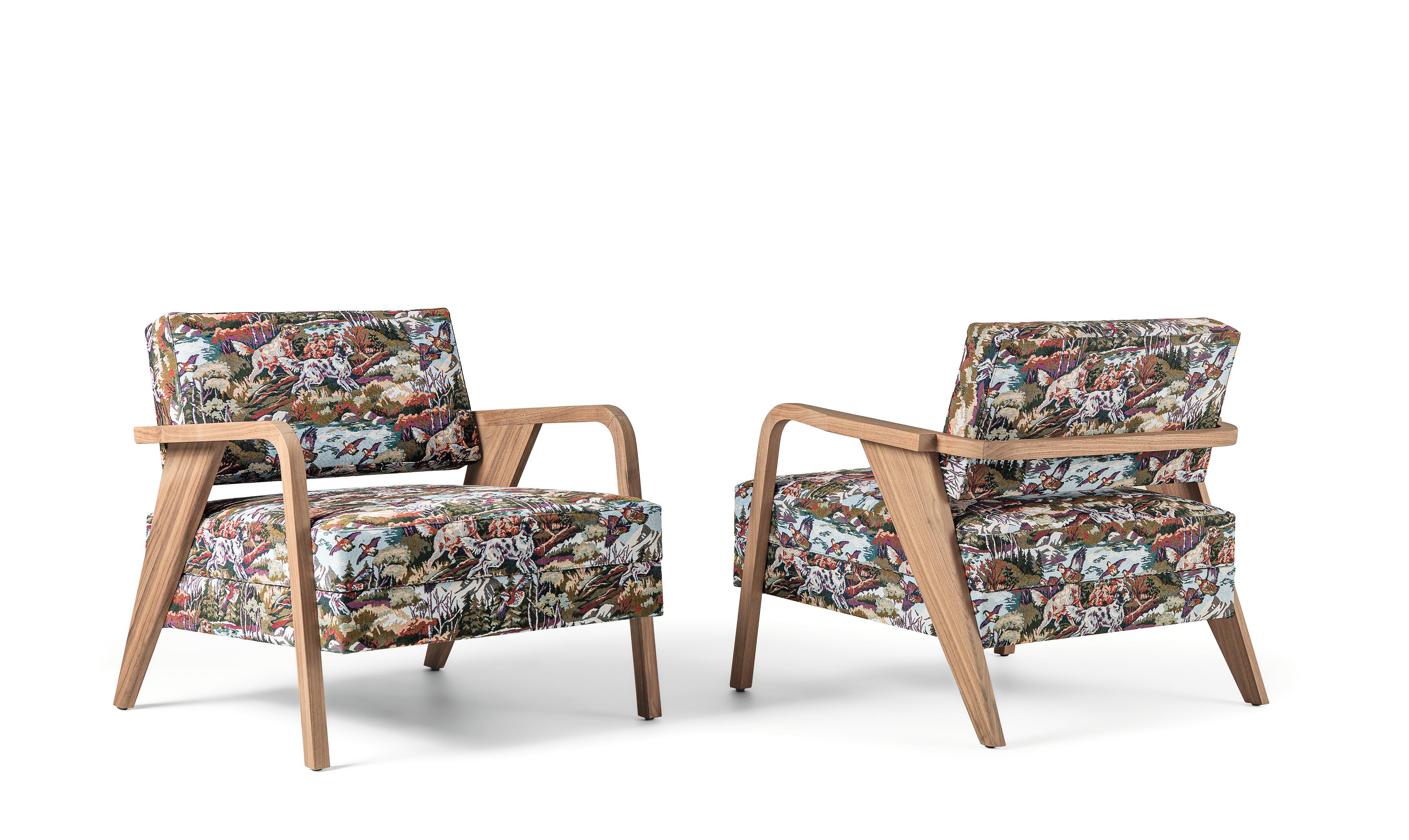 Lounge armchair designed by Storagemilano Studio. The armchair is made of solid Canaletto walnut wood, then finished in matt natural 2% gloss. Upholstered with fire retardant foam, the fabric depicts a hunting scene. Available in COM and with