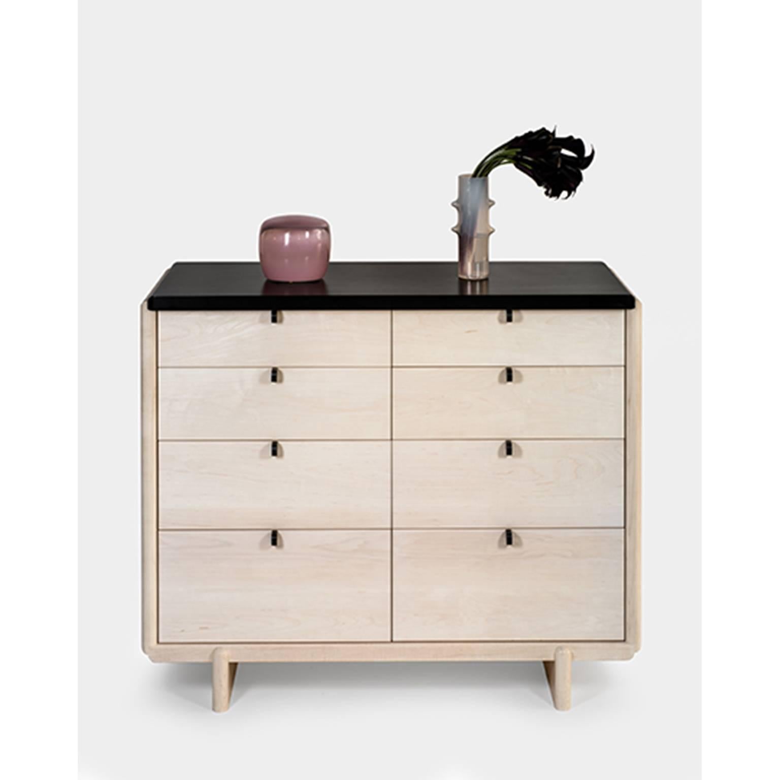 Nocturne Chest softens the acute rectilinear details of traditional case construction with a composed series of undulations in the joinery. These bleached maple elements are punctuated by the bold, matte, black solid surface top and pulls. The