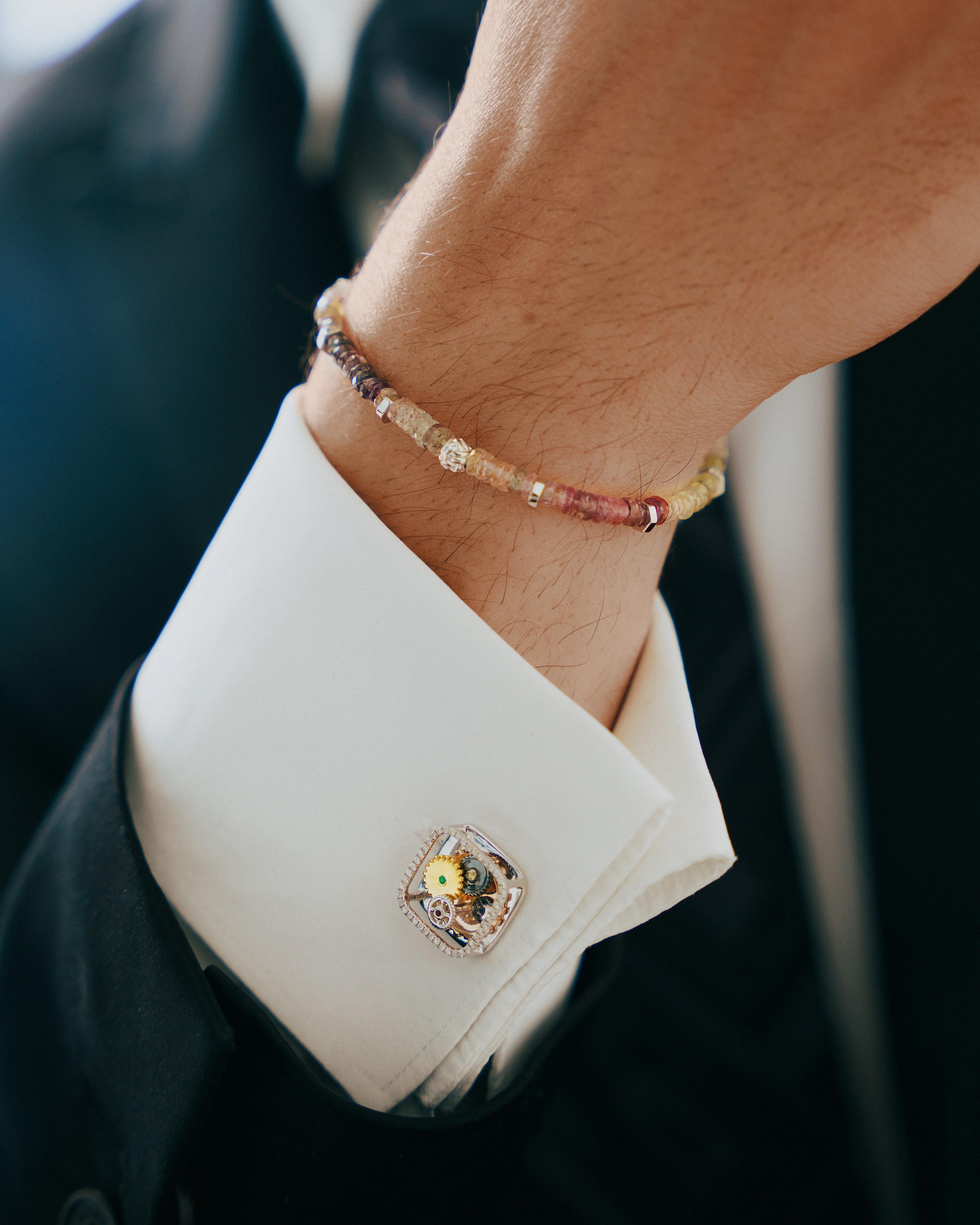 Tateossian continues to explore and find beauty in rare and less traditional precious stones. This hand strung beaded bracelet is made up of multicoloured sopphires for a sparkling rainbow effect. It also features a central silver knot bead and our