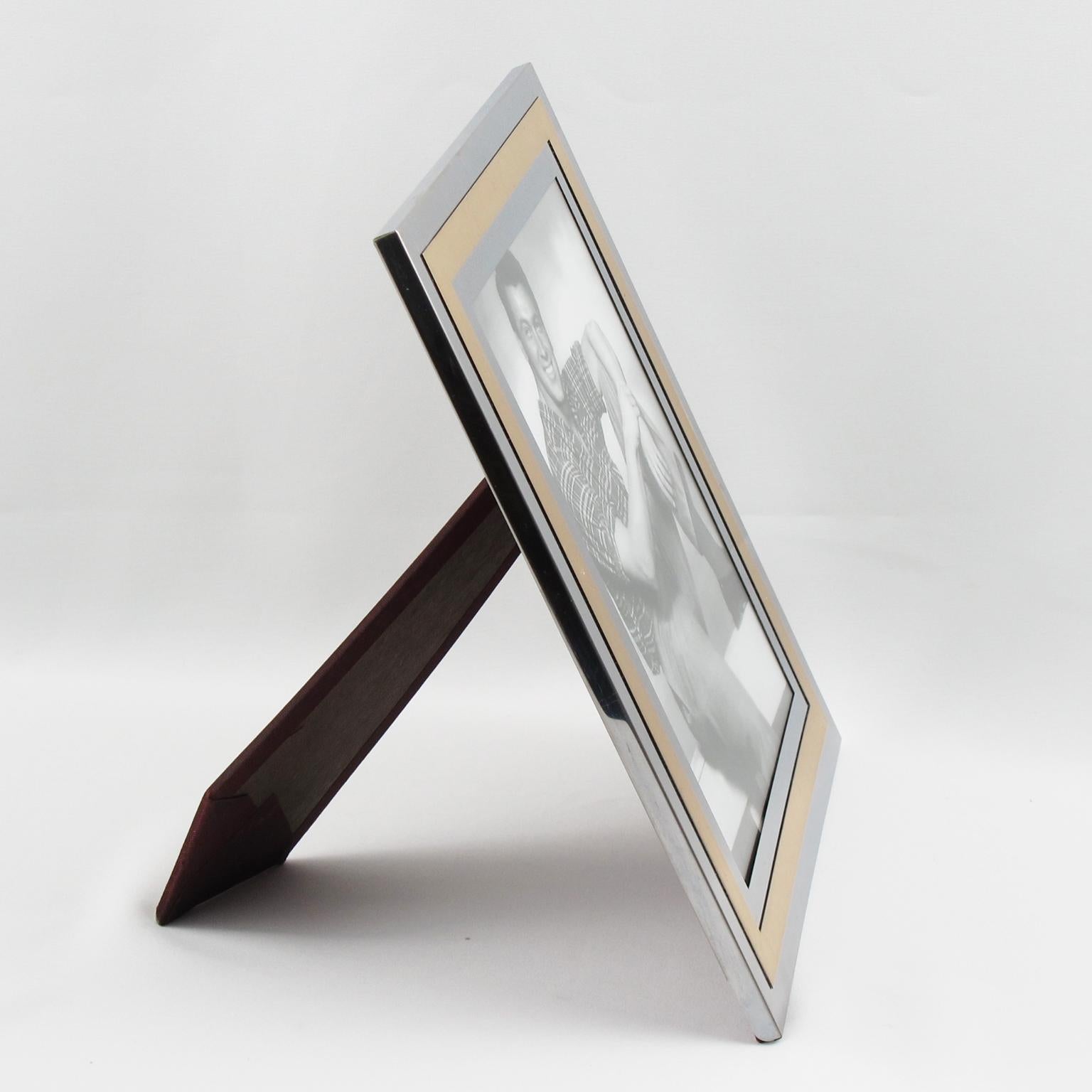 Elegant 1970s modernist picture photo frame by Italian designer Noel B.C. Gilt brass and chrome metal geometric design. Silver and gold color. Back and easel in dark red fabric. The frame can also be hanged on a wall. Picture frame can be placed in