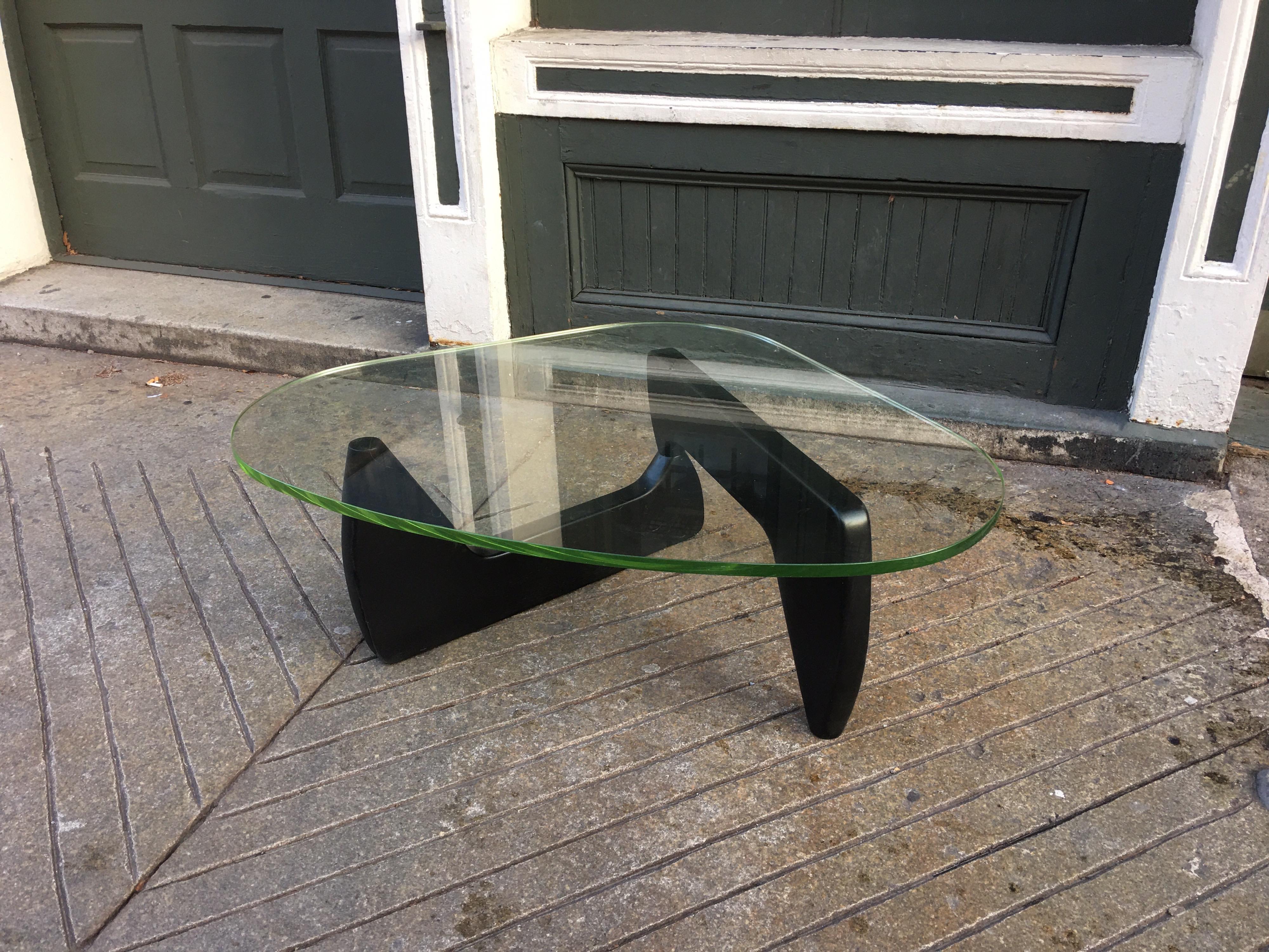 Noguchi style wood and glass coffee table. Two part base held together with a large wood dowel. Beautiful original glass has a nice greenish tint. 3/4