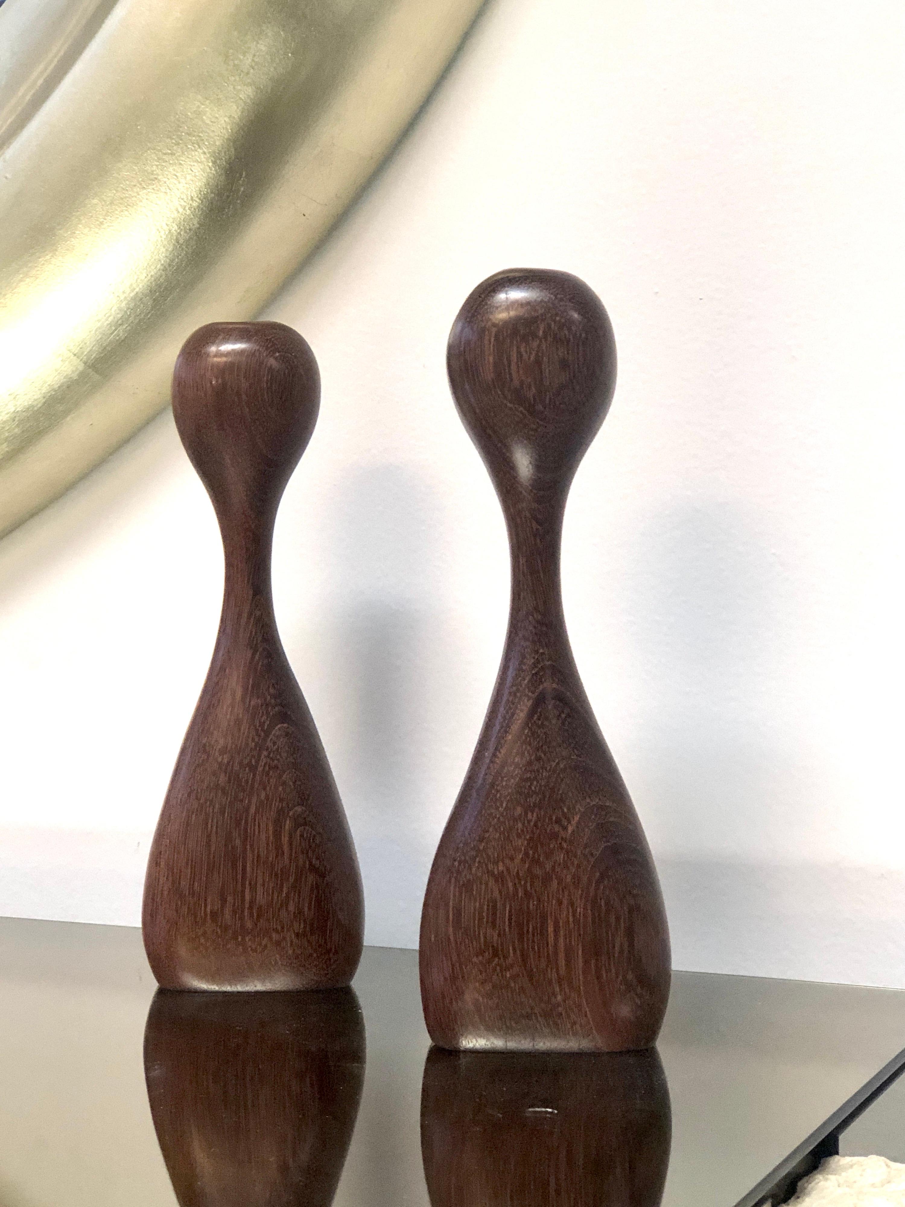 A pair of sculptural candleholders. Done in an organic style, seemingly identical, with subtle but noticeable differences that can only be achieved by a master sculptor. Tallest is 11.5”, the second one is 11”.