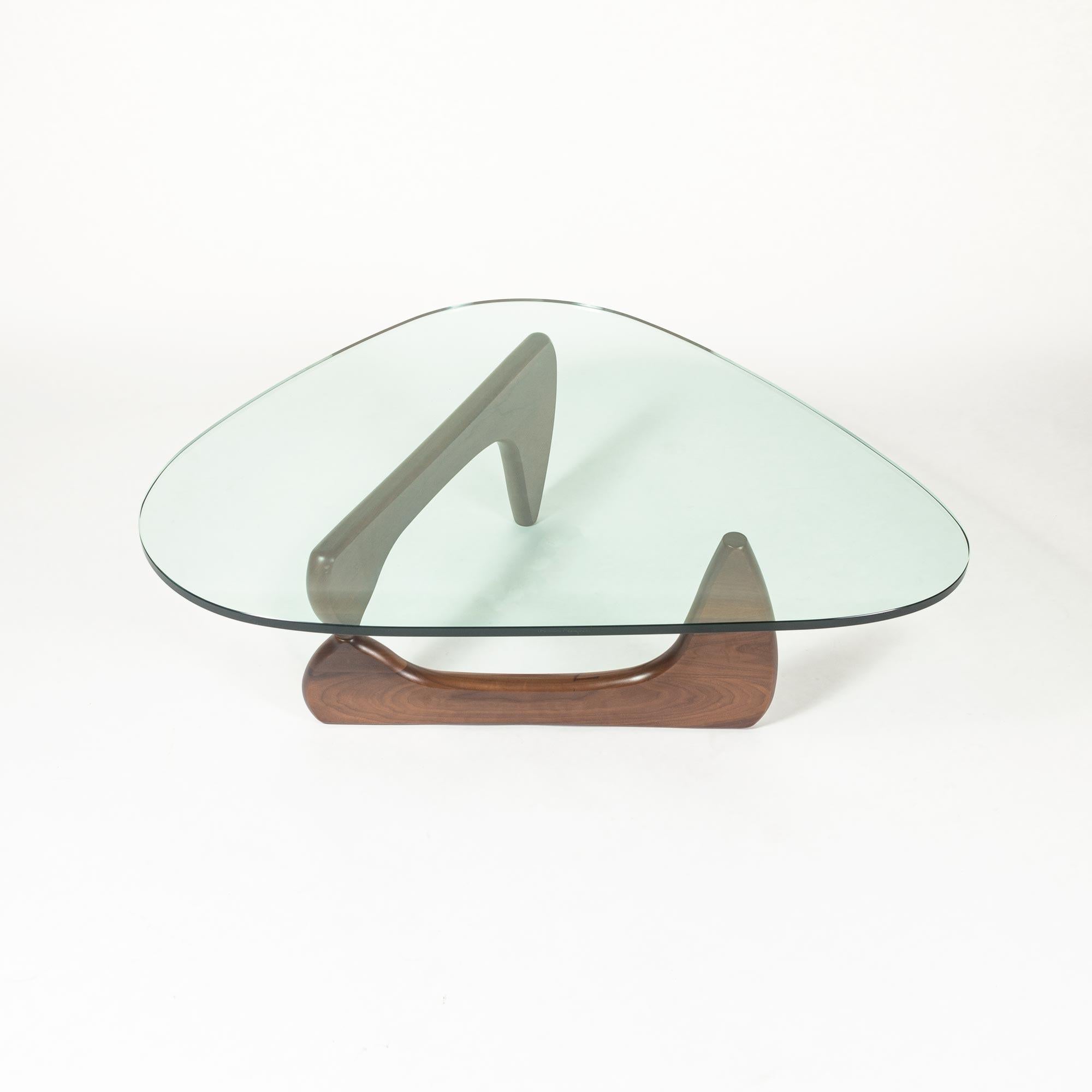 A Classic Mid-Century Modern design by Isamu Noguchi for Herman Miller. Heavy 3/4 inches thick glass sits on top of walnut frame perfectly balance and still. Designer's signature on the edge of the glass, and manufacturer label on the frame remains.