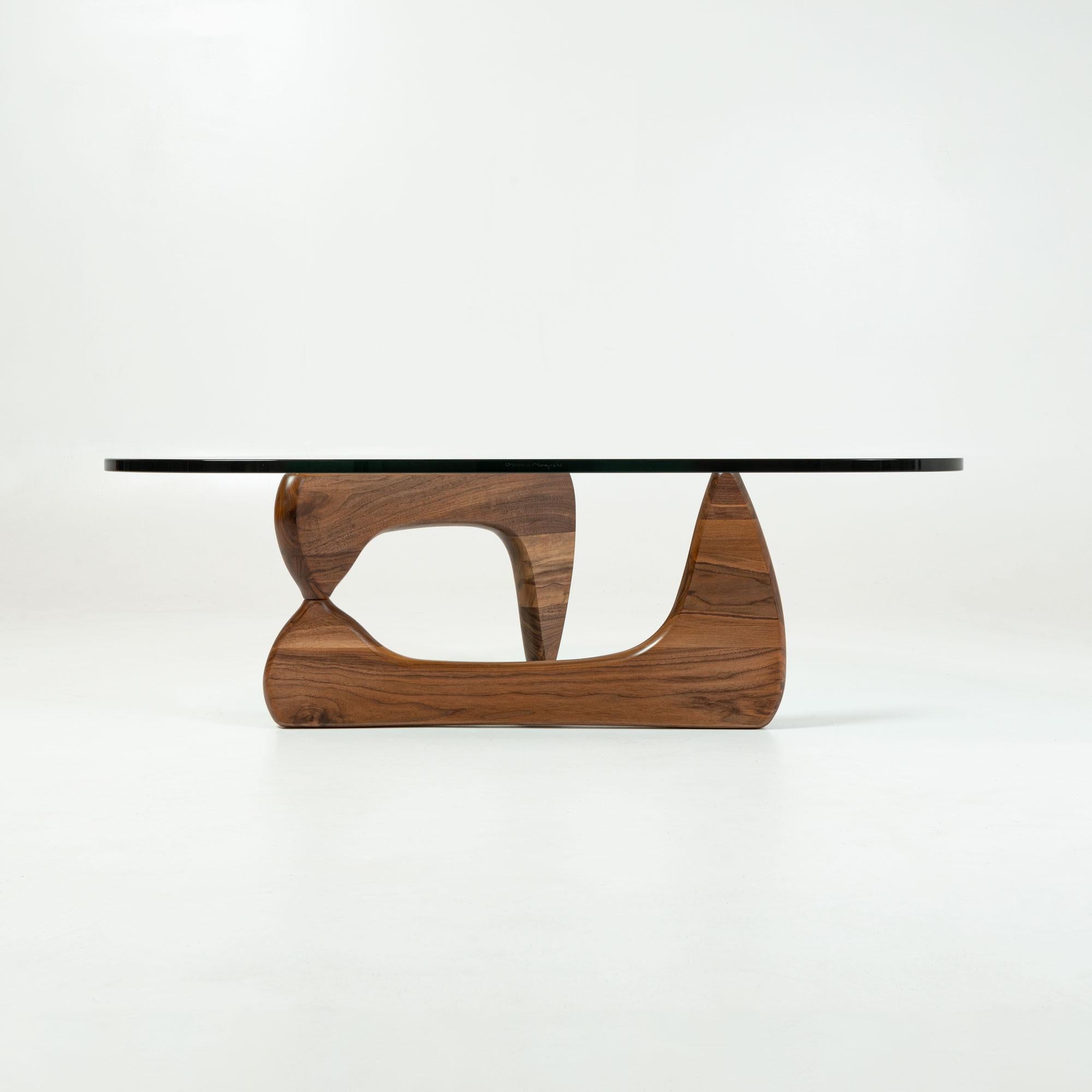 This original Noguchi Table (IN50) balances delicacy with sturdy, solid walnut construction in an understated yet unforgettable icon. The signature interlocking wood base offers a fresh perspective from every angle while the thick glass-top is made