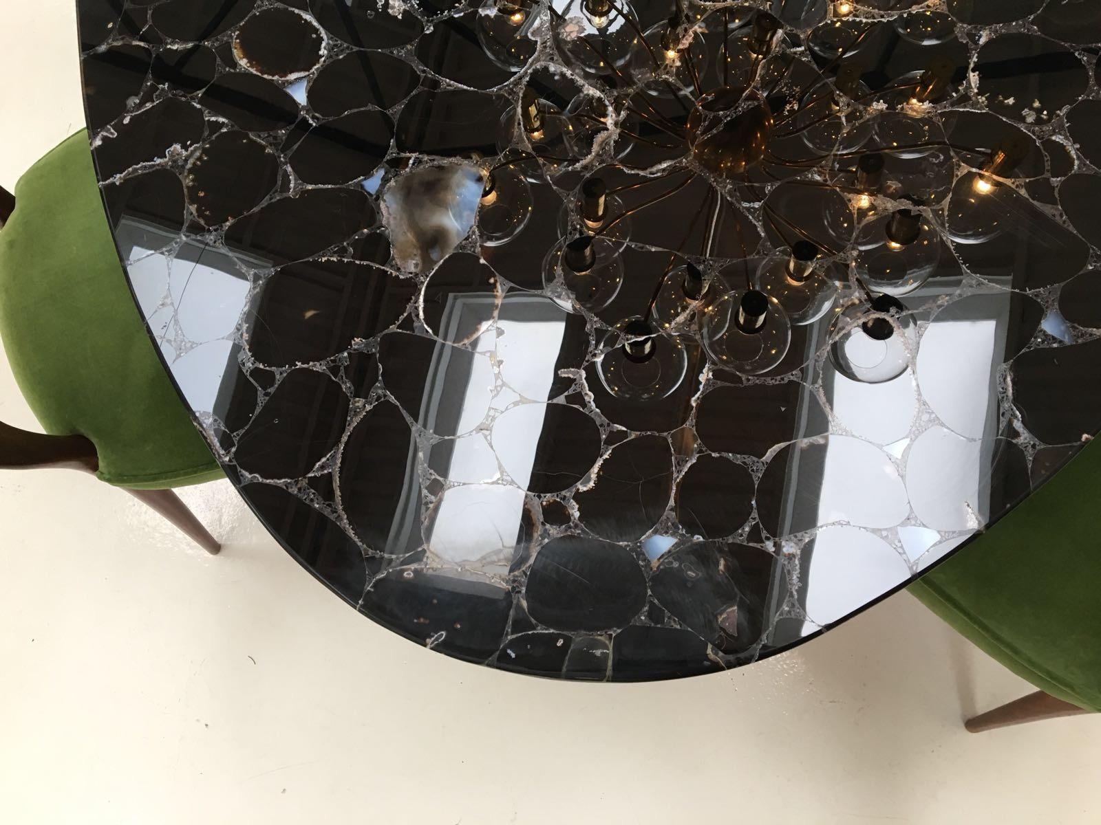 Indulge and enjoy a lifetime of beauty. 

This table is a luxurious piece of collectible design combining precious Noir Désir black agate gemstone - an exceptional gemstone with a lavish translucent and opaque combination - cut in an in elliptical