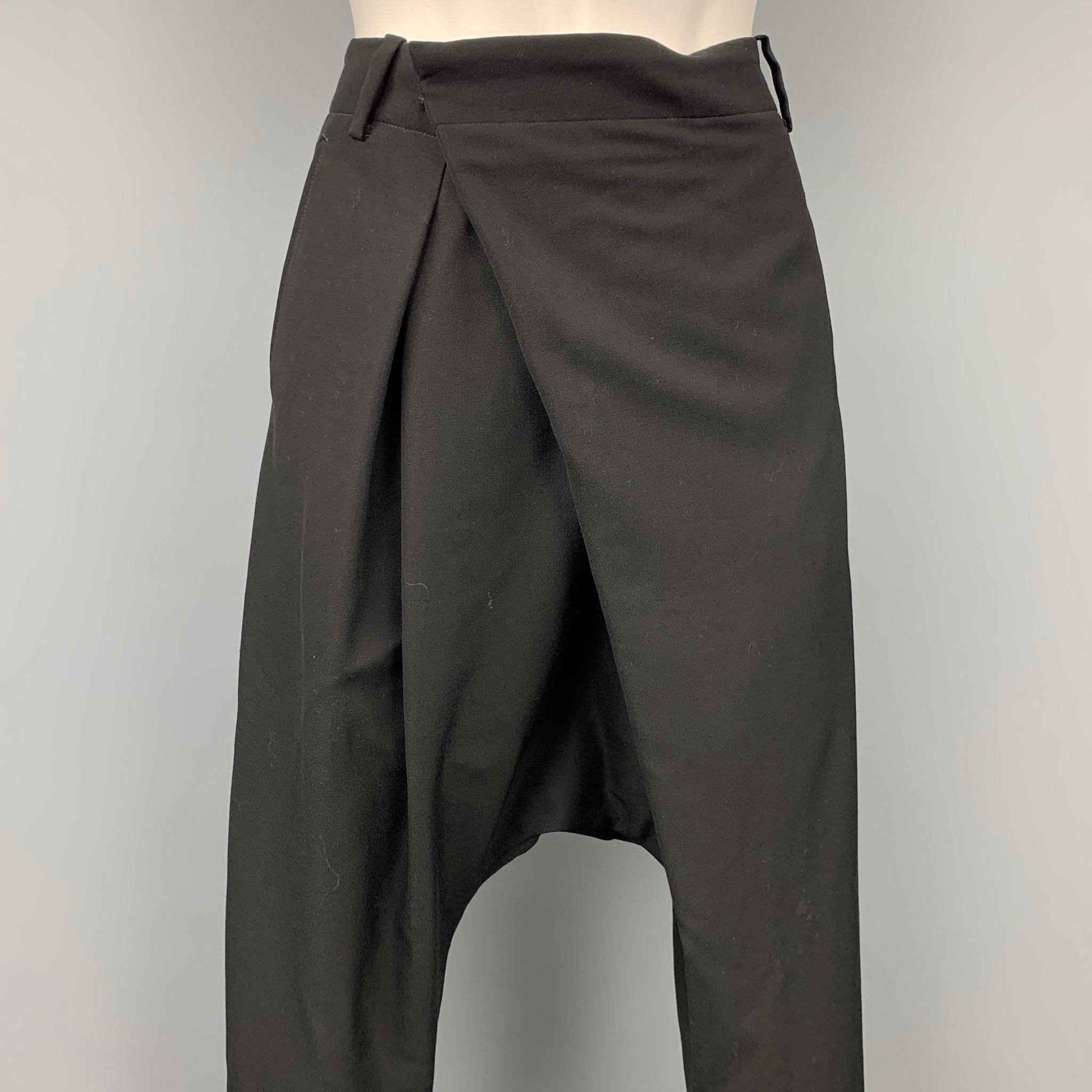 NOIR KEI NINOMIYA for COMME des GARCONS dress pants comes in a black wool featuring an asymmetrical design, drop-crotch, slit pockets, and a front tab. Made in Japan.

Very Good Pre-Owned Condition.
Marked: S / AD2015
Original Retail Price: