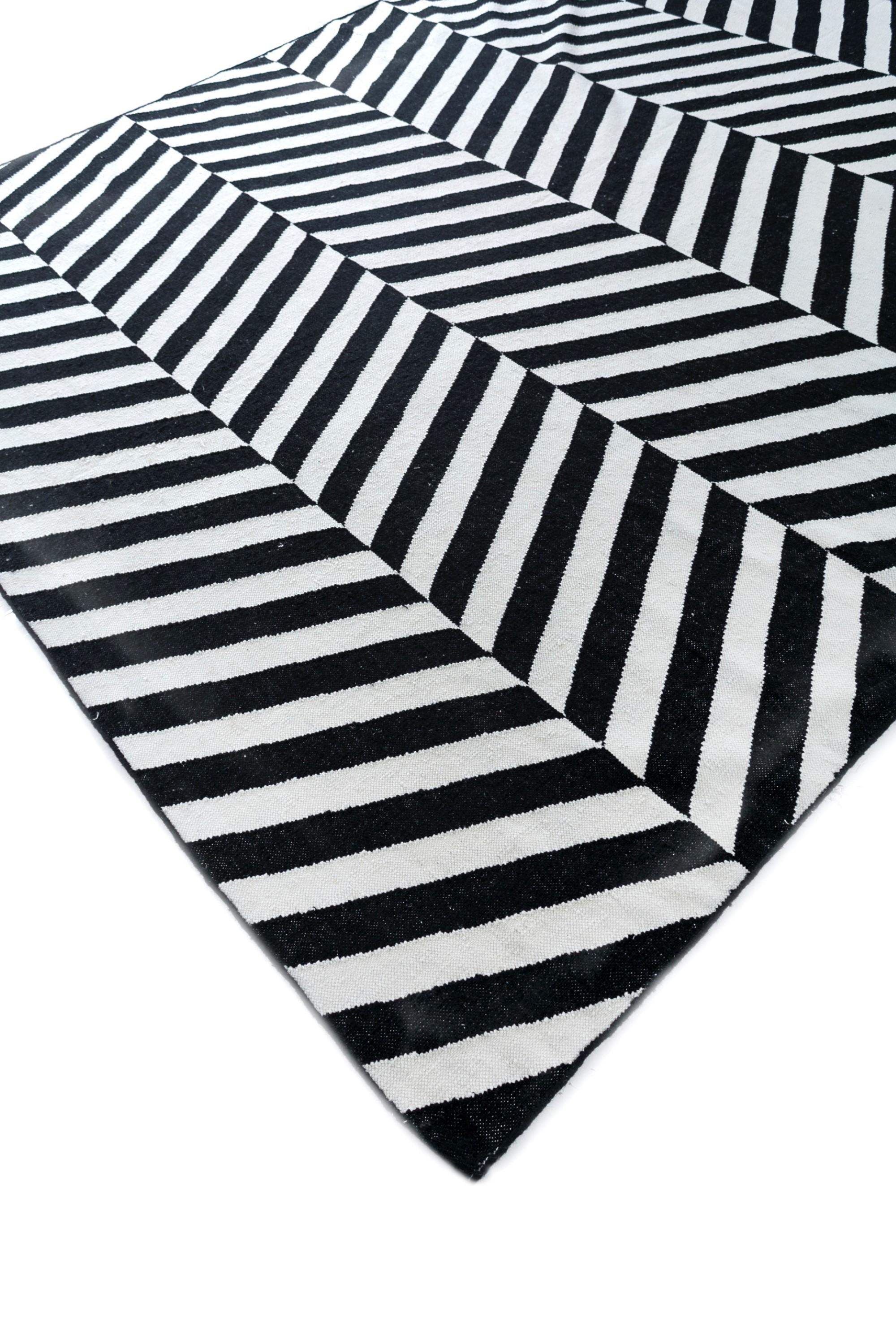 Esta alfombra de la colección Indusbar, única en su género, es un complemento visualmente cautivador para cualquier espacio. Esta alfombra rectangular presenta un intrigante diseño en ricos tonos ébano, creando un centro de mesa lujoso y atemporal