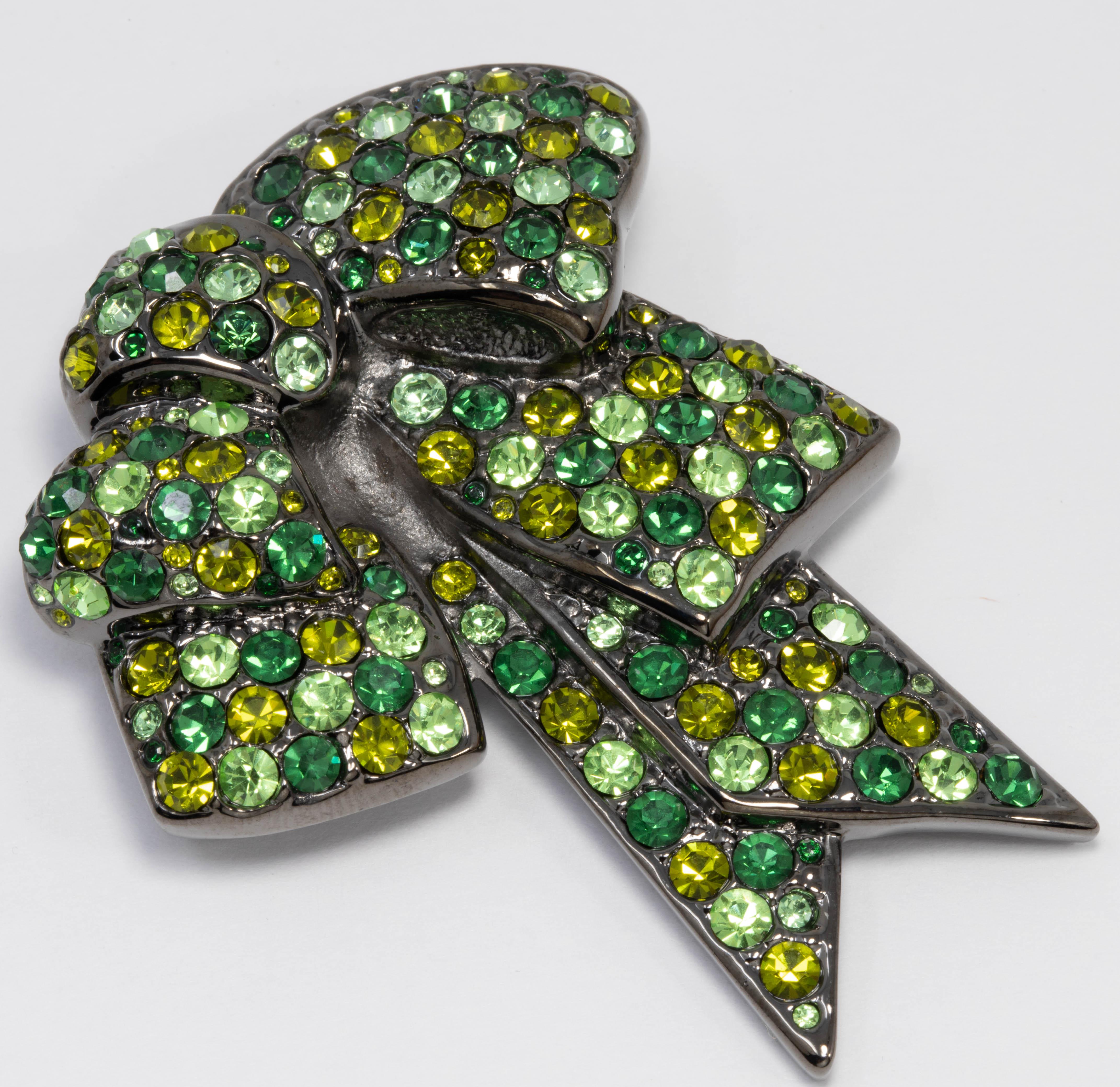 A sophisticated bow pin by Nolan Miller. Glittering green pave crystals are set on a dark gray gunmetal-tone setting.

Tags, Marks, Hallmarks: Nolan Miller
