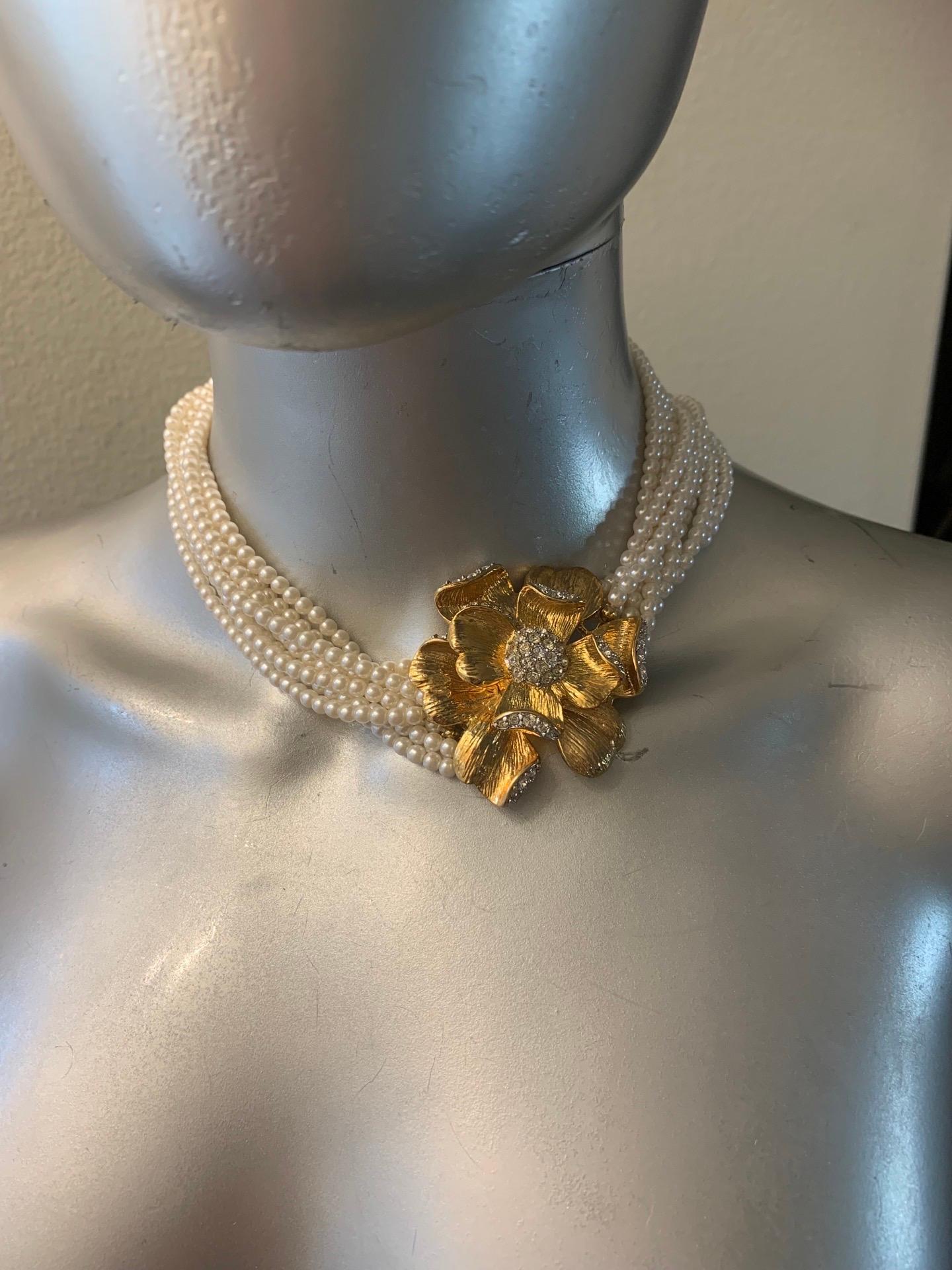 8 strands of faux pearls (the look so real!!!) and a beautiful spring blossum flower in textured gold plate. Rhinestone accents. All by Dynasty TV show designer, Nolan Miller. This chic necklace was part of a collection that included beautiful clip