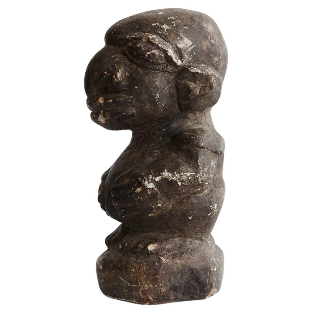 A Nomoli is a carved stone figurine native to Sierra Leone and Liberia. They are usually made of soapstone, limestone, or granite.

The carving depicts a man holding his belly with a disproportionally large head with a large nose, eyes, and lips