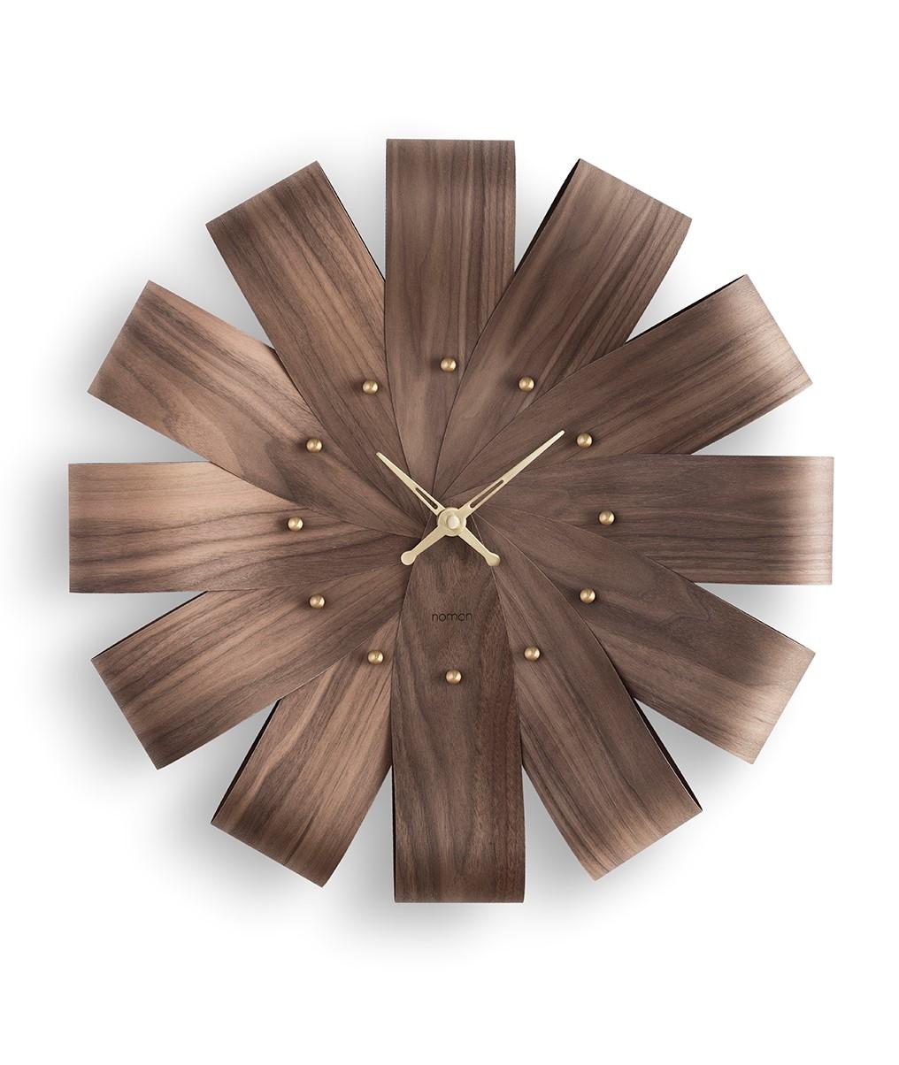 FOR THE FIRST TIME, NOMON WORKS WITH SUBTLY FOLDED WOODEN STRIPS. THE SILHOUETTE CONNECTS US WITH NATURE, EMULATING AN OPEN FLOWER IN ALL ITS SPLENDOR.
Clock made with natural walnut or oak sheets.
The subtle folds of curved wood create