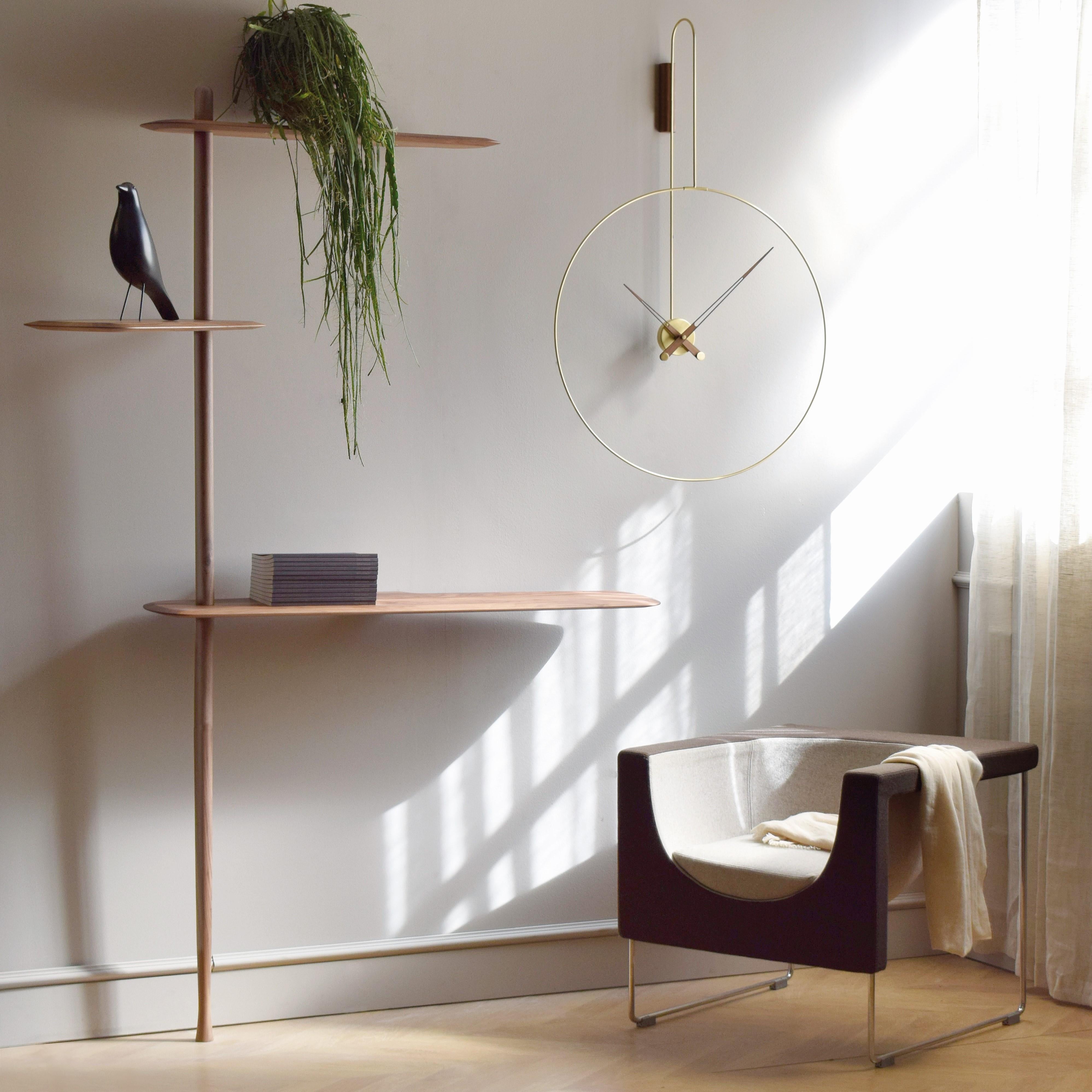 ø70cm clock with a length of 108 cm, characterized by its curved, polished brass elements. Hands in natural walnut wood.


Available in Walnut, Brass