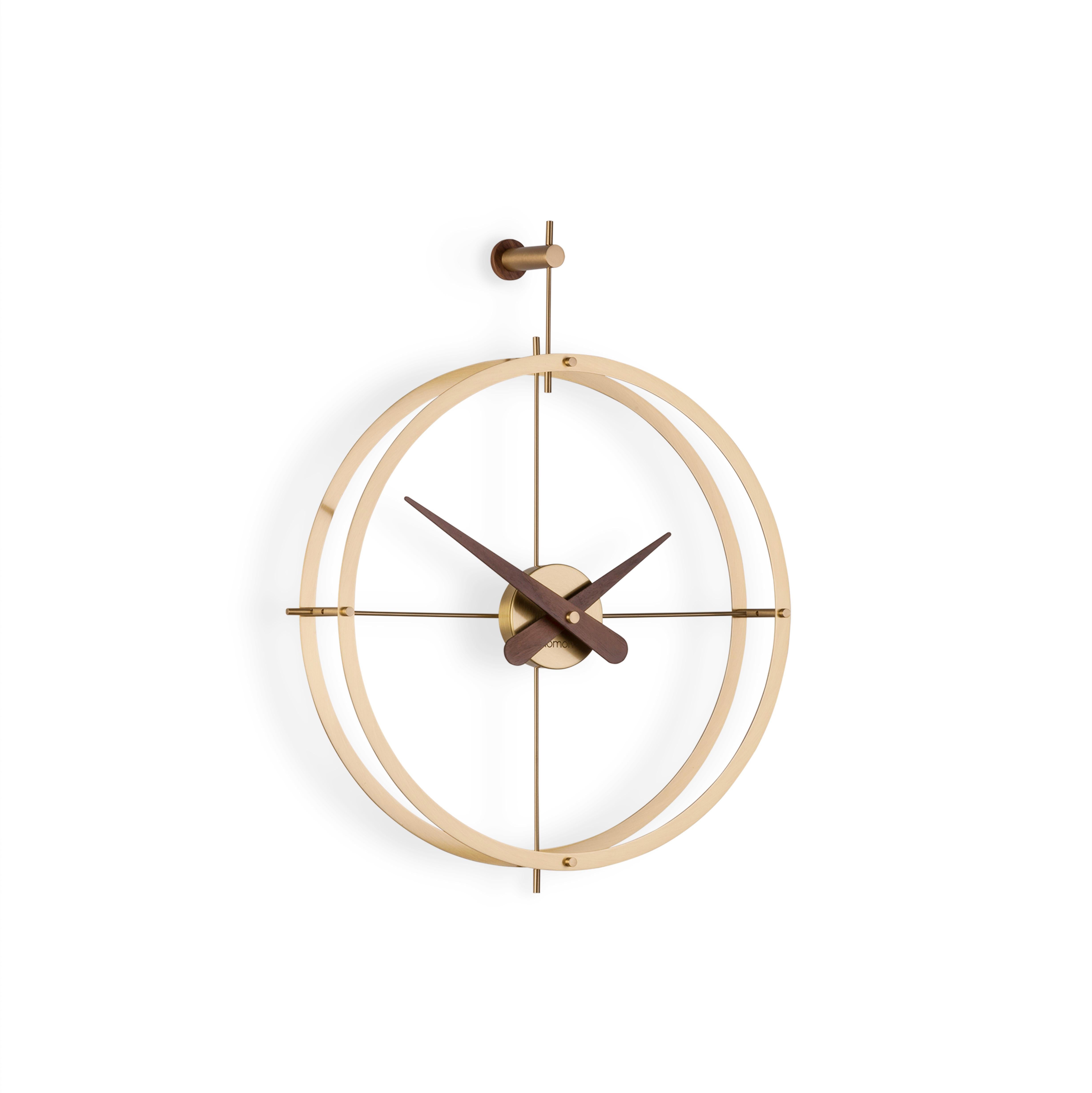 Clock that exudes elegance and sophistication, with rings made of polished brass, combined with hands in natural walnut wood.

Rings and central box in polished brass, hands in walnut wood.