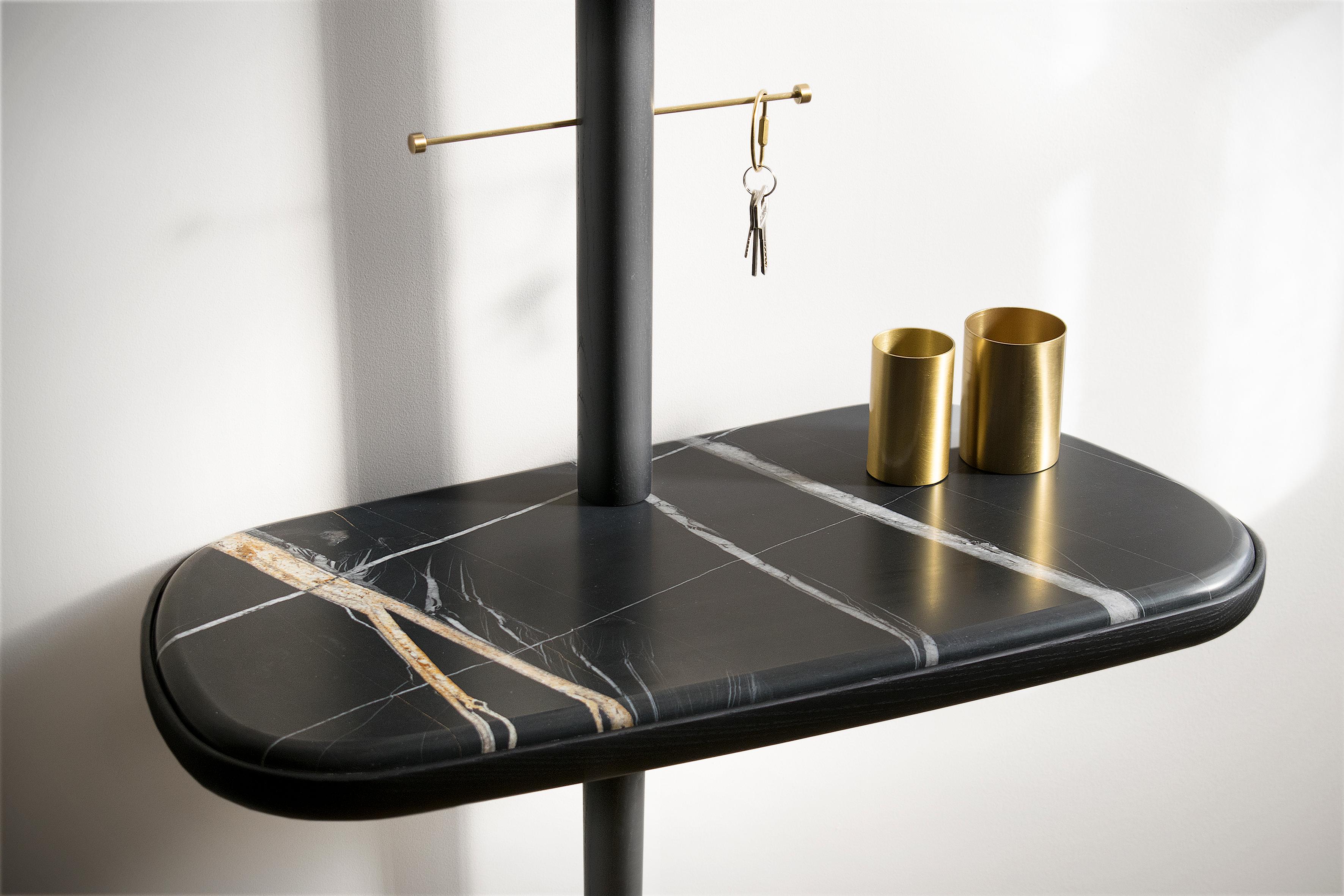 Timeless piece due to its minimalist and warm design. The original gold rod sophis- ticates the traditionality of the piece.

Available in Walnut, Emperador Marble, Black Ash,  Sahara Noir