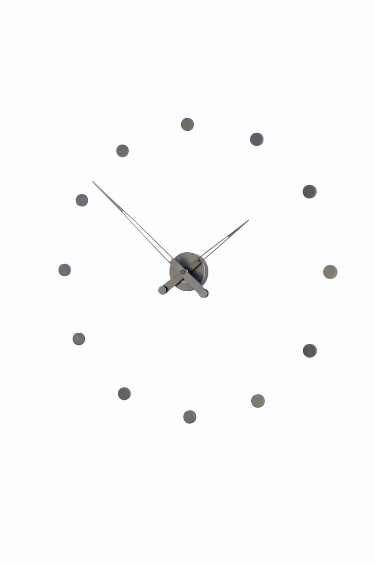 Reloj Mini Merlin de Nomon. Reloj de pared adhesivo de acero y nogal.